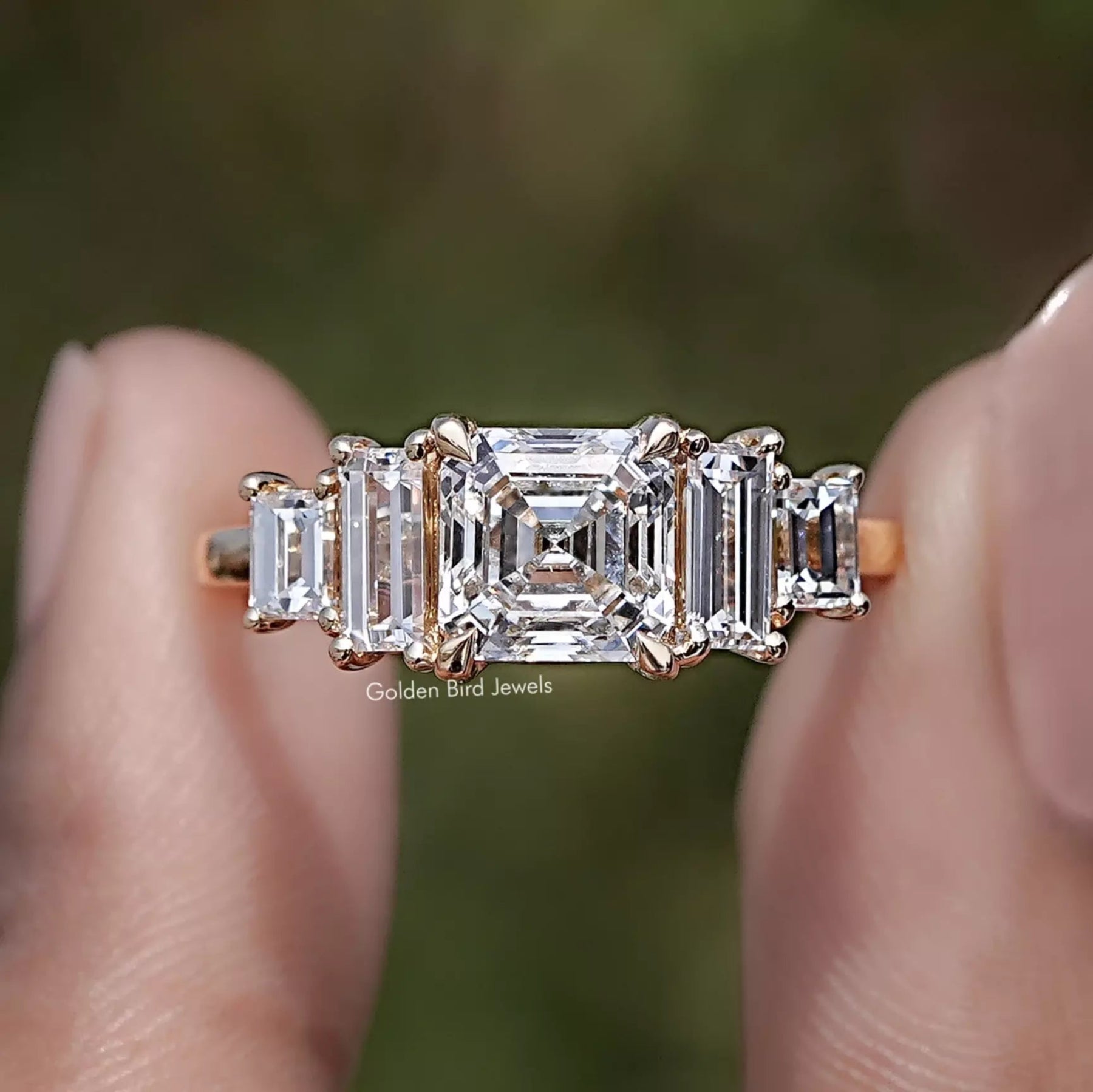 Asscher Cut Lab Diamond Five Stone Ring Between Two Fingers