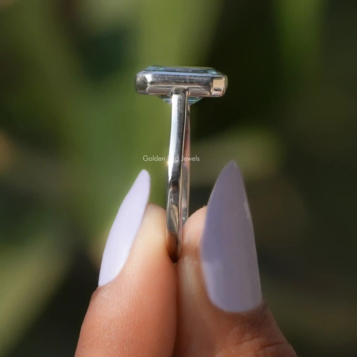 Side View A Green Emerald Cut Solitaire Ring on a two fingers