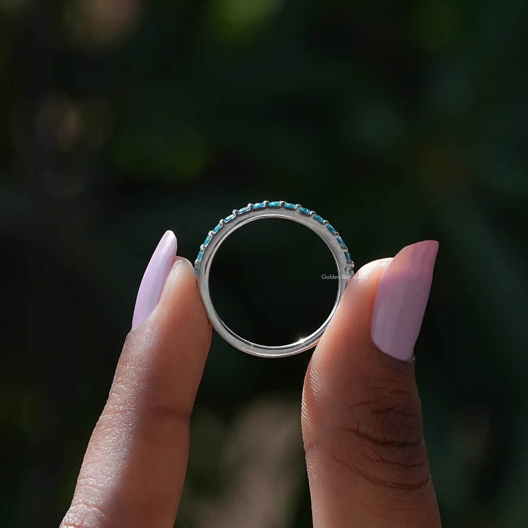 Back view of Blue Topaz Round Eternity Band in secure setting