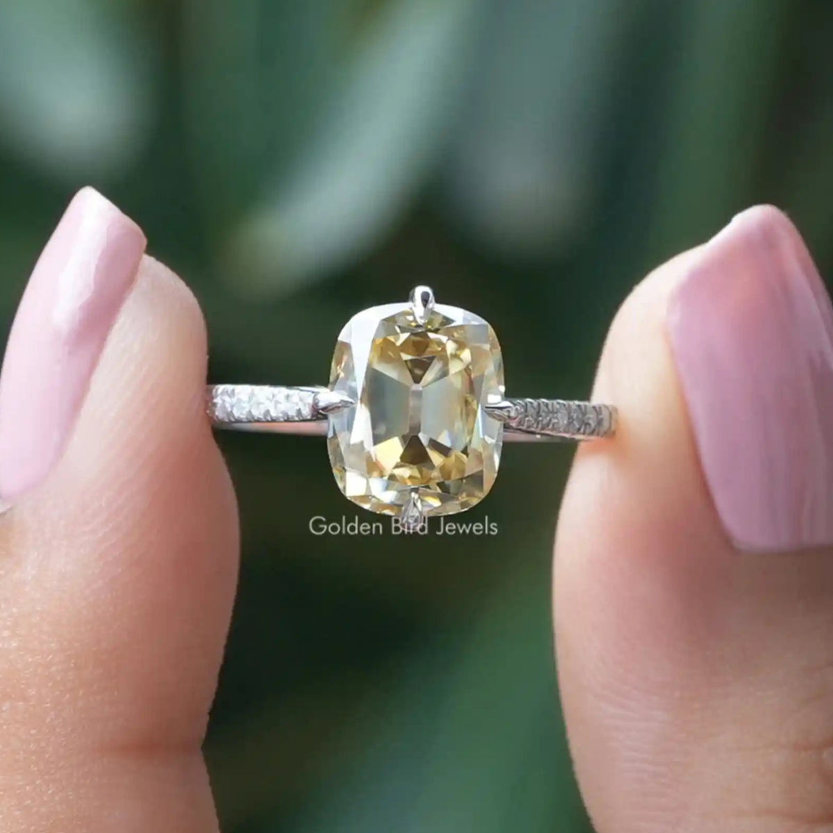 Two fingers holding the Old Mine Cushion Cut Moissanite Accent Stone Ring