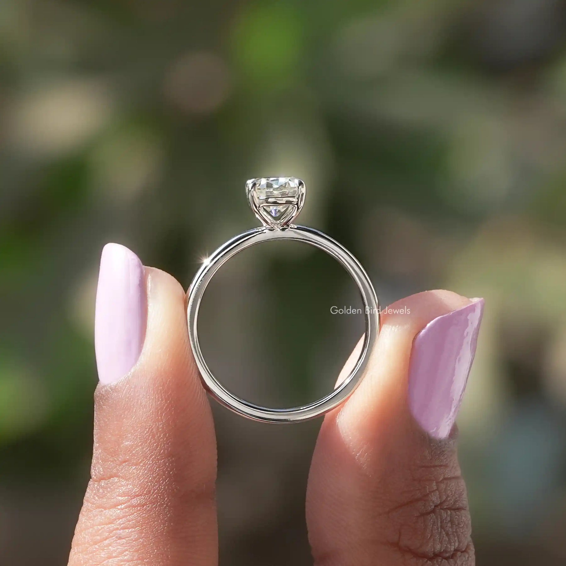 Back View of Cushion Cut Moissanite Solitaire Ring In two fingers