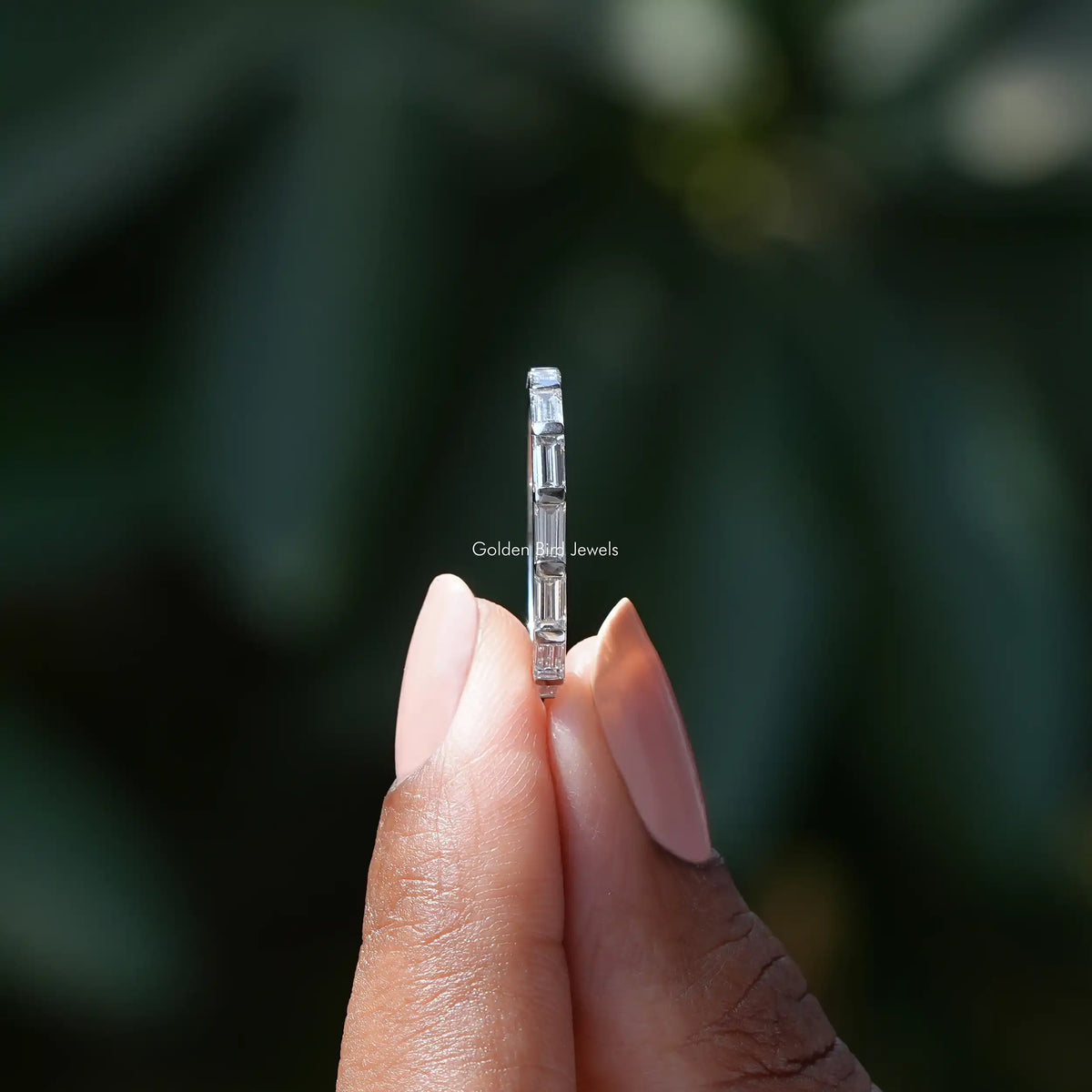 Side View of baguette cut wedding band In two fingers