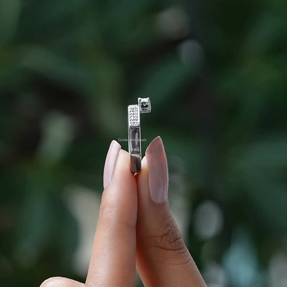 Side View of Emerald Cut Moissanite Ring In two fingers