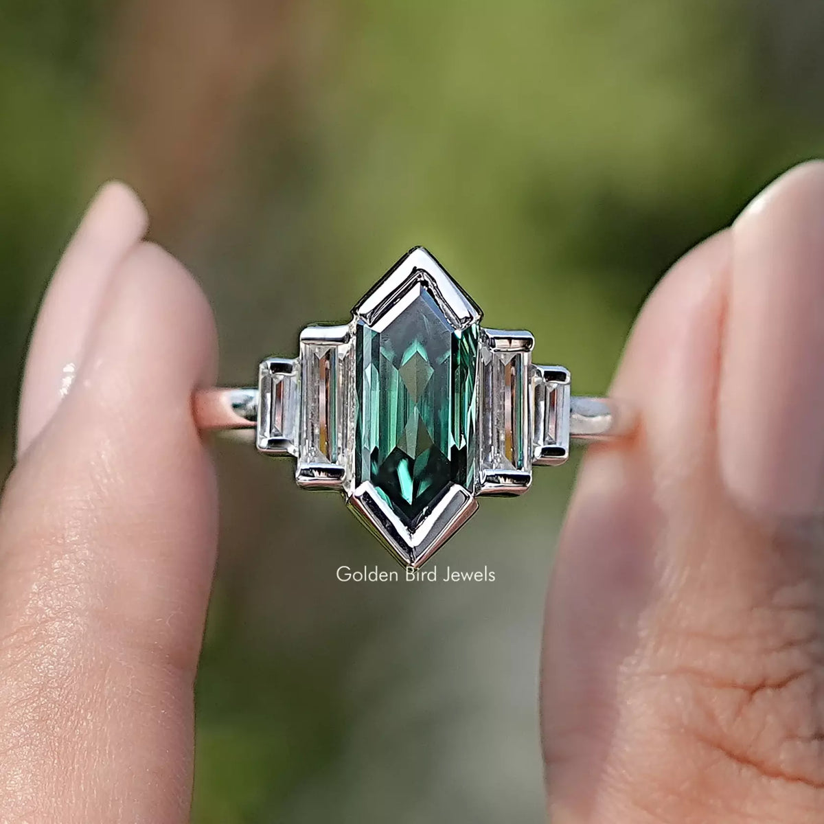 Front view of Elongated Hexagon Cut Moissanite Five Stone Ring in two fingers