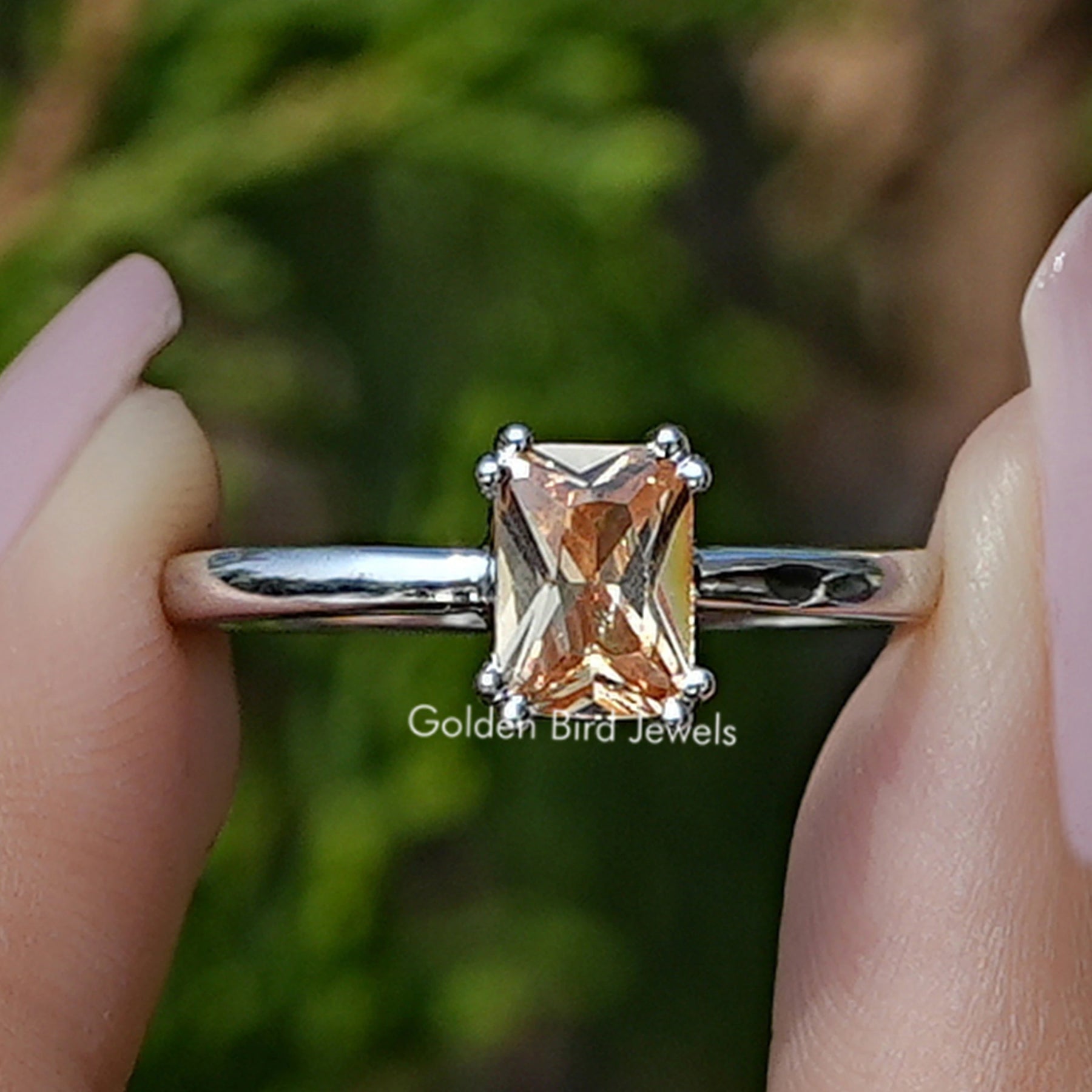 Front view of Citrine Orange Emerald Gemstone Ring Set in two fingers