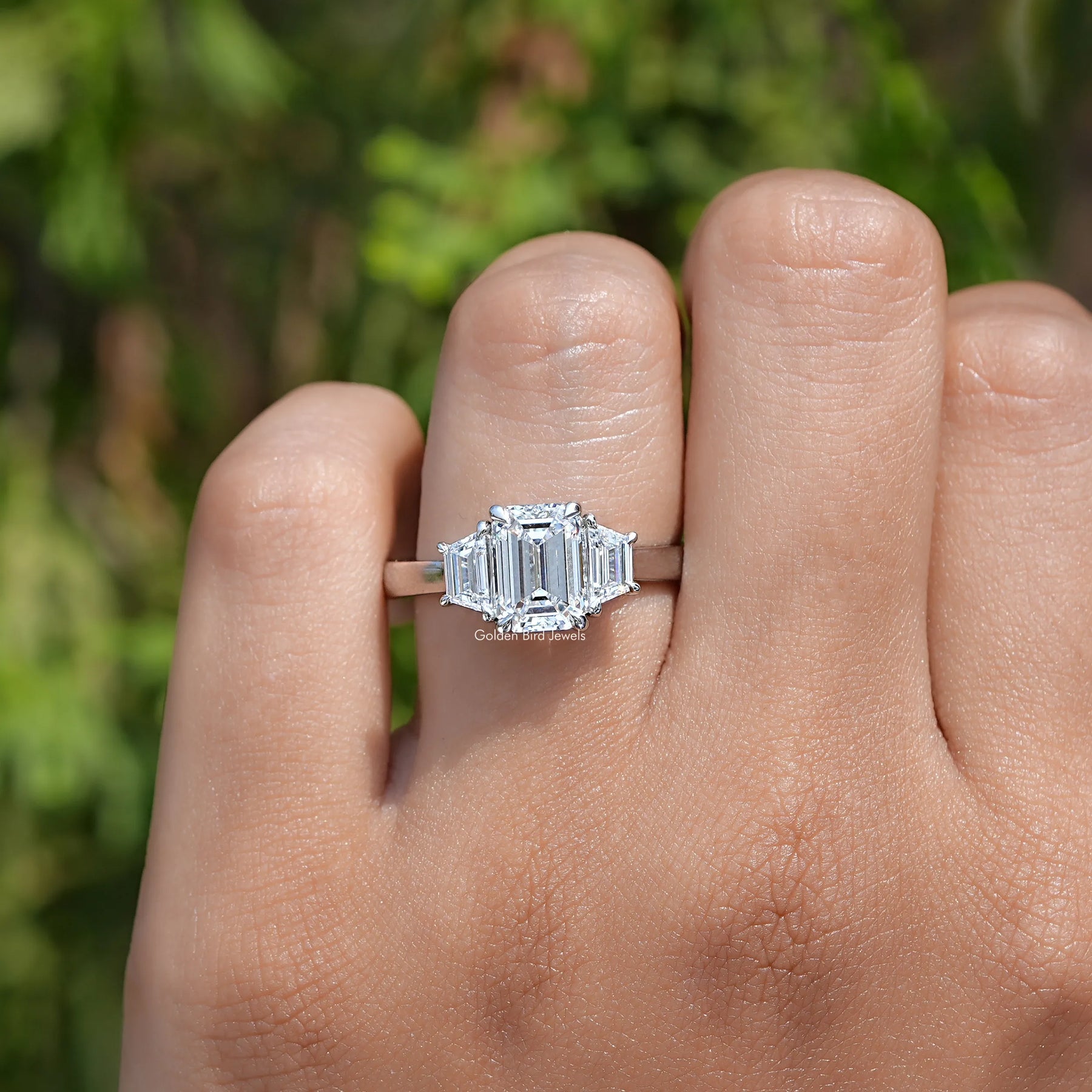 View of Emerald Cut Three Stone Engagement Ring In Yellow Gold