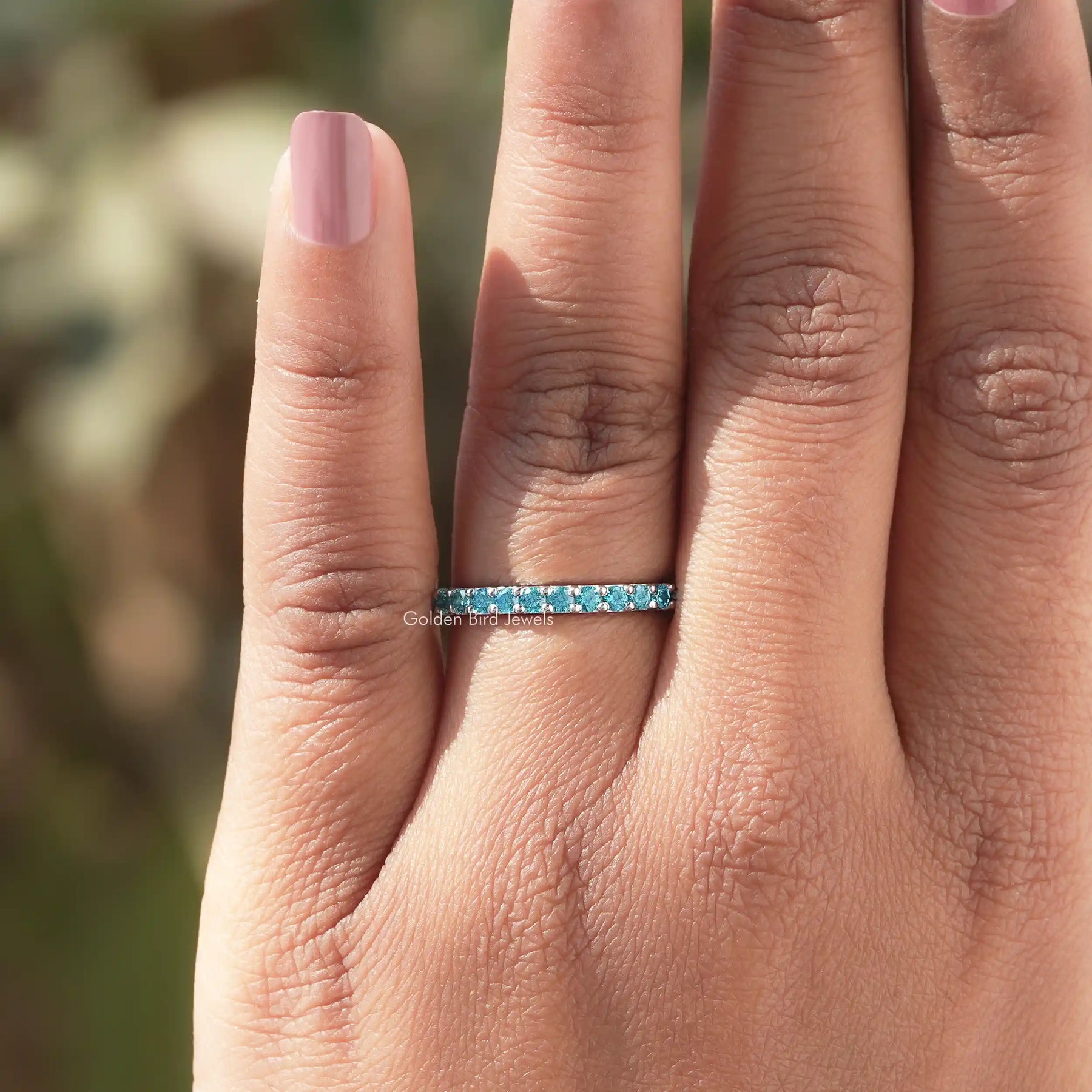 In finger view of Blue Round Cut Moissanite Solitaire Ring