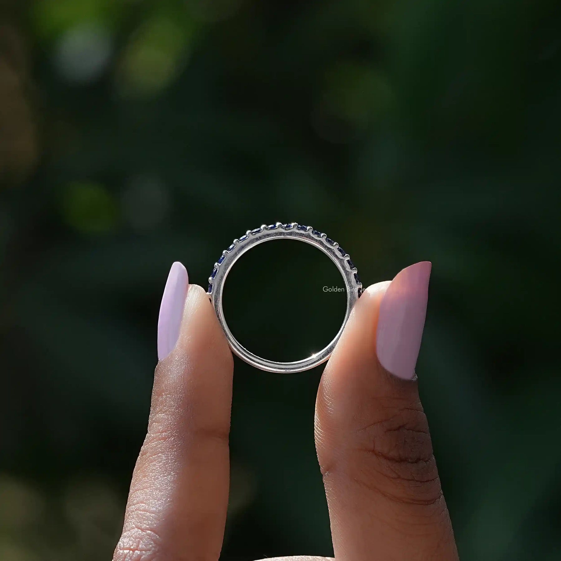 Back view of Sapphire Blue Round Eternity Band in secure setting