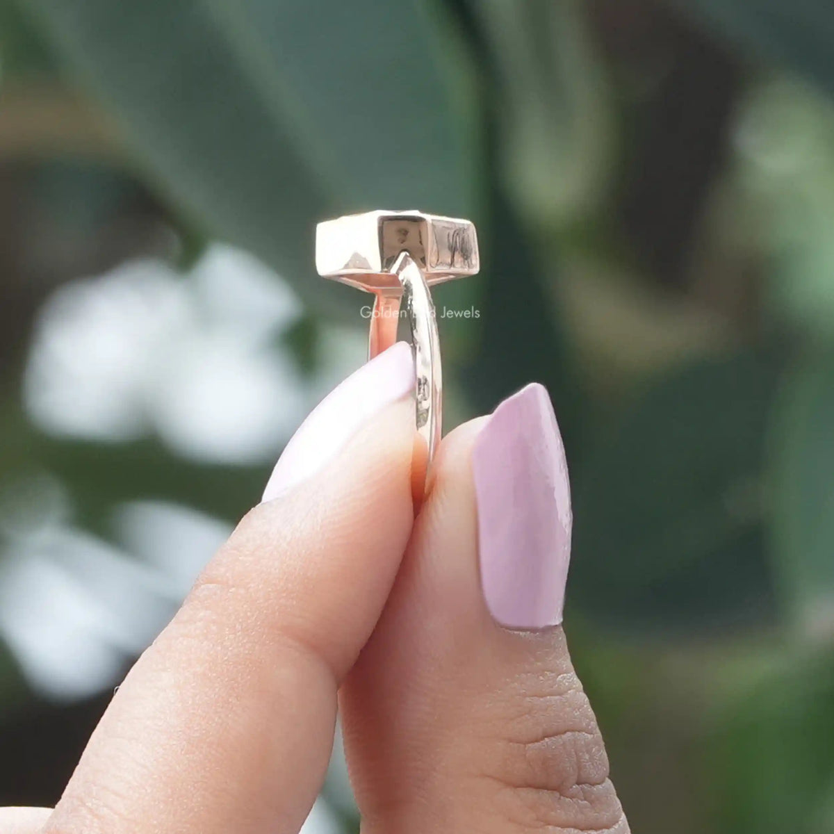 Side View Of Marquise Cut Engagement Ring In two Fingers