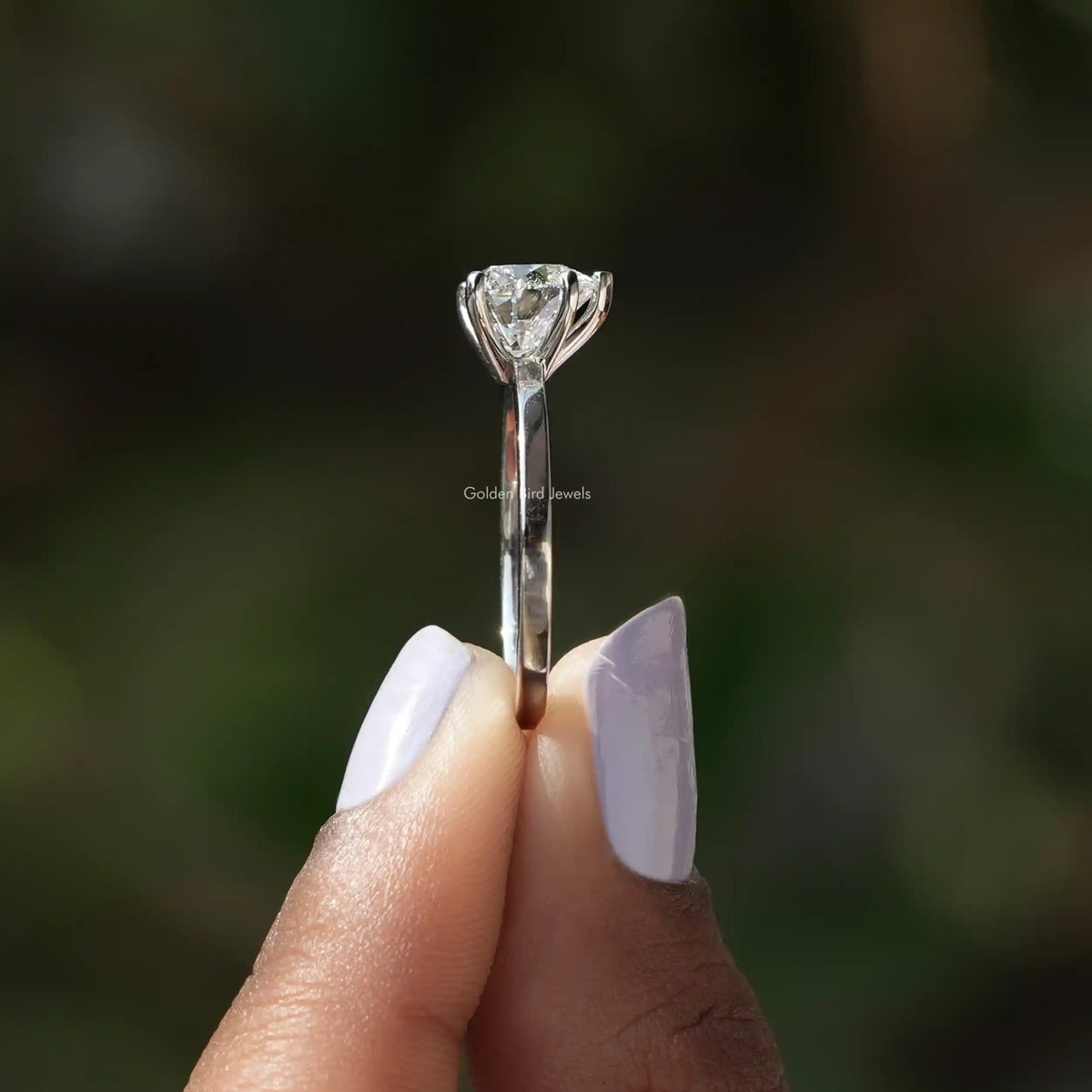 Side View of Heart Cut Diamond Solitaire Ring In two fingers