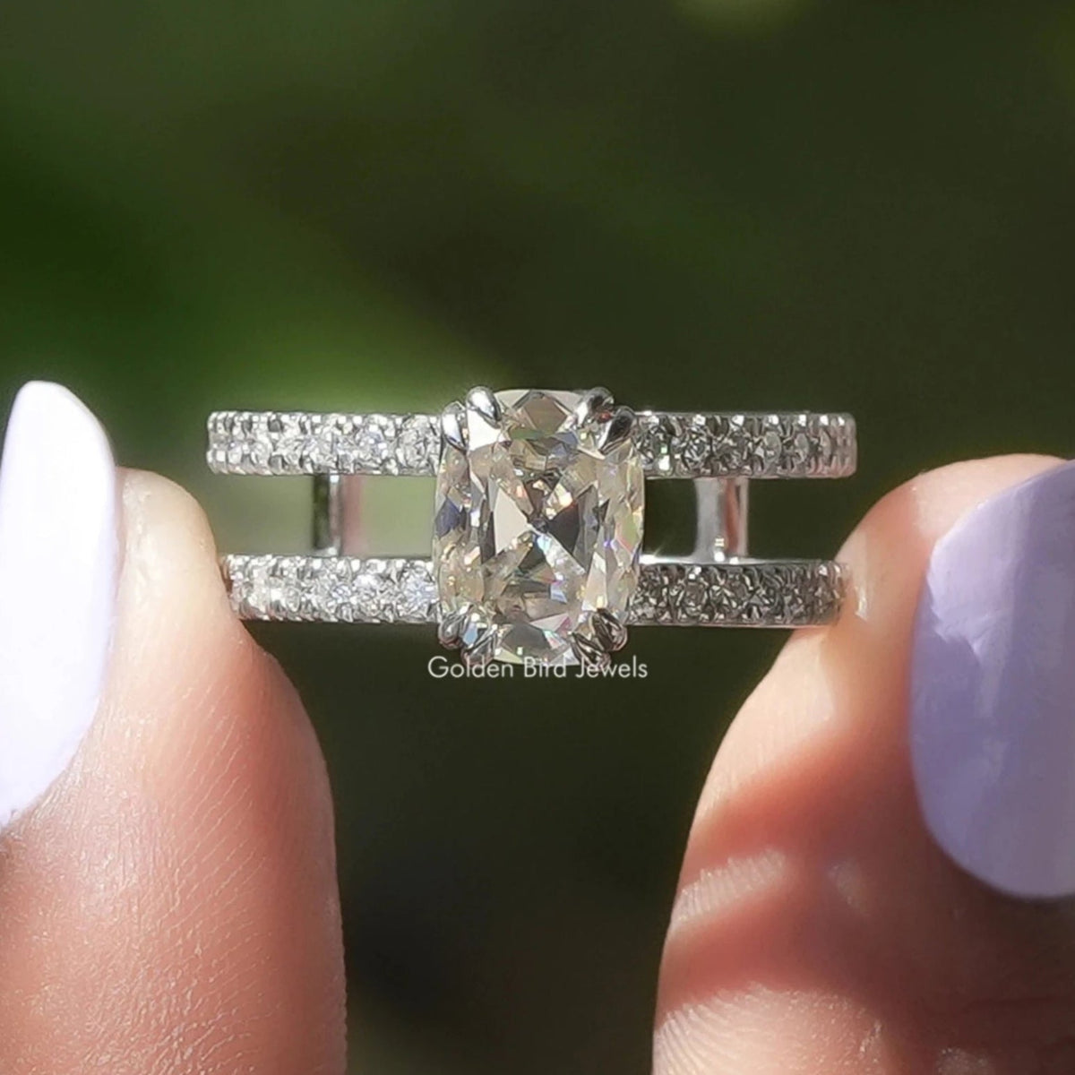 Two fingers holding the Old Mine Cushion Cut Moissanite Engagement Ring