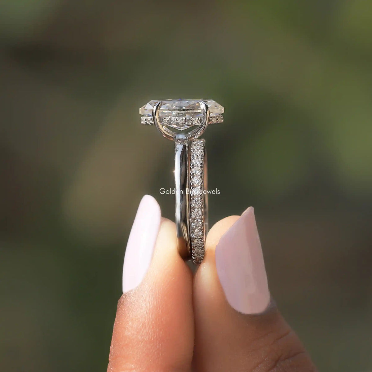 Side View of Marquise Cut Moissanite Halo Bridal Ring Set In two fingers