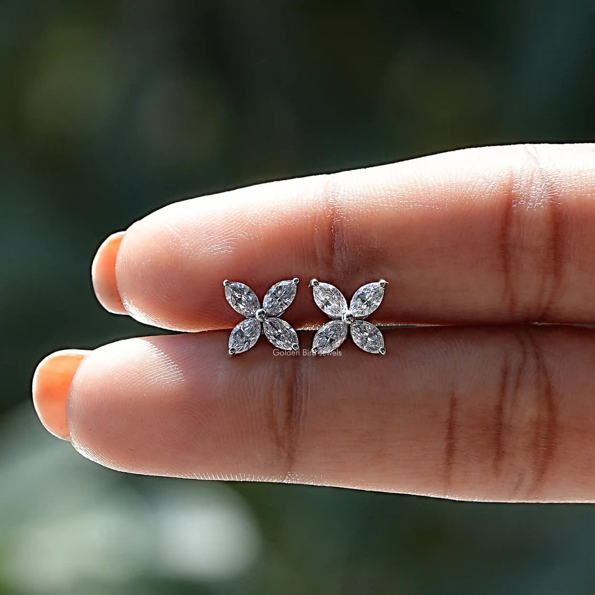 Diamond studs earing in holding on center of fingers