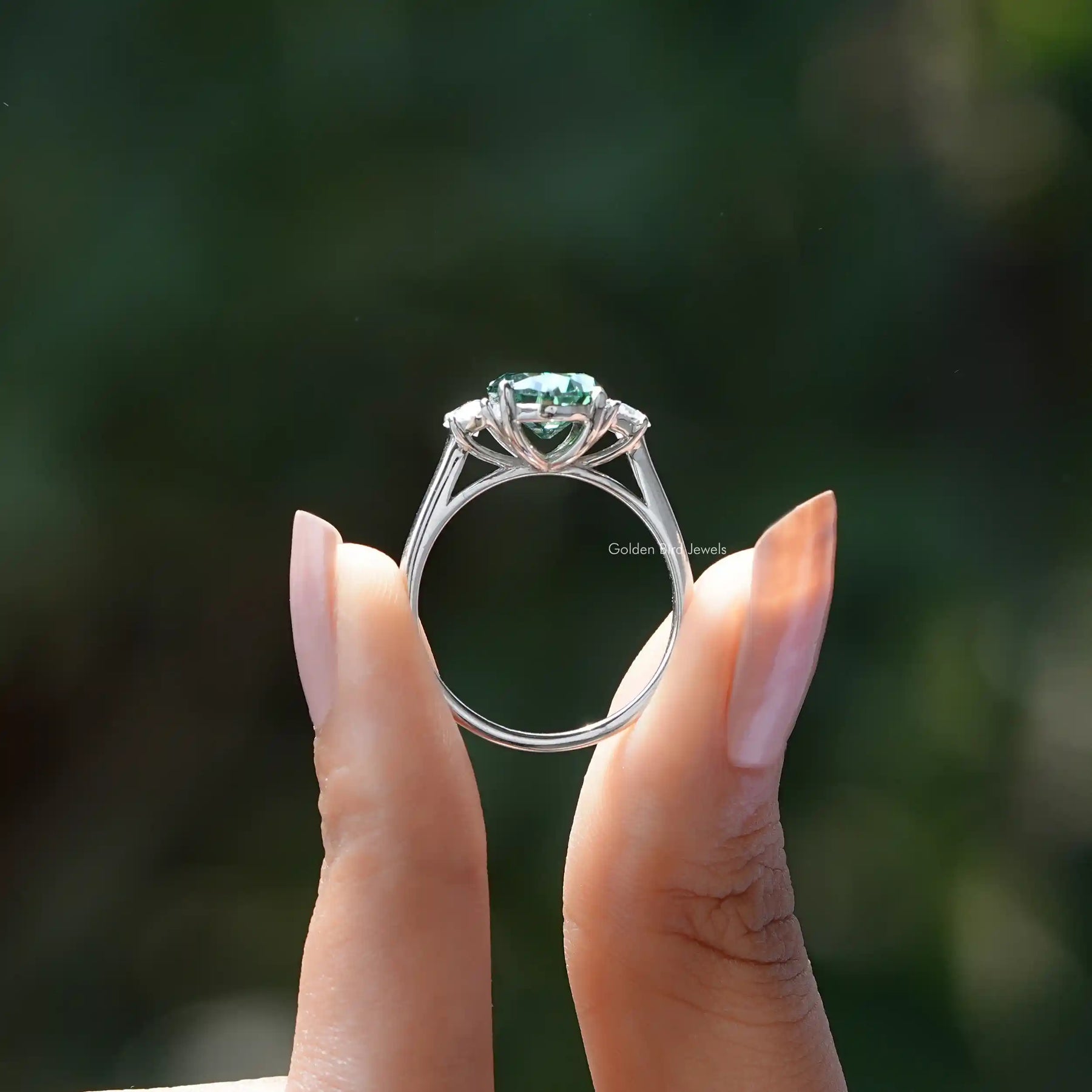 Back View of Oval And Half Moon Three Stone Ring In two fingers