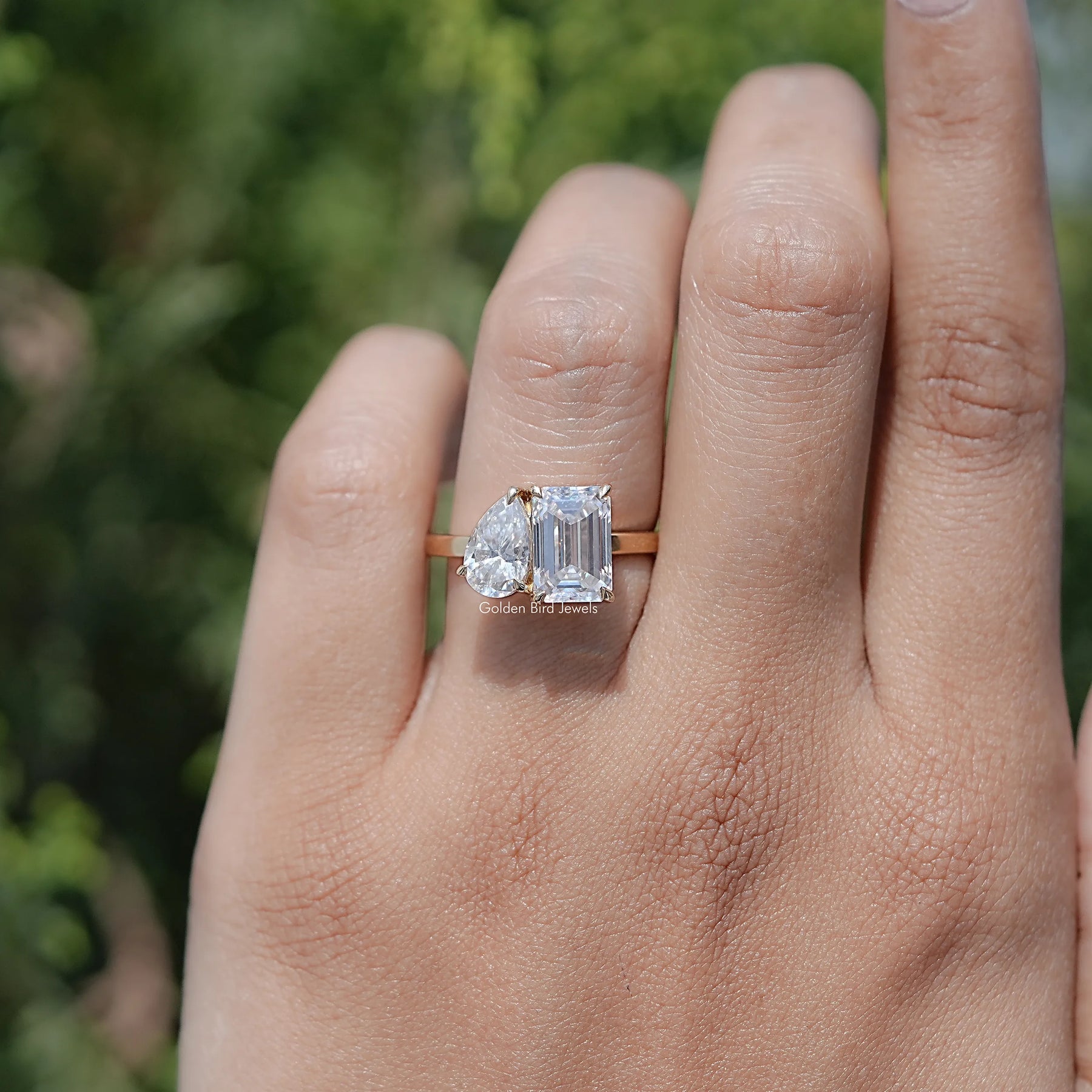 In finger view of Pear And Emerald Cut Moissanite Solitaire Ring