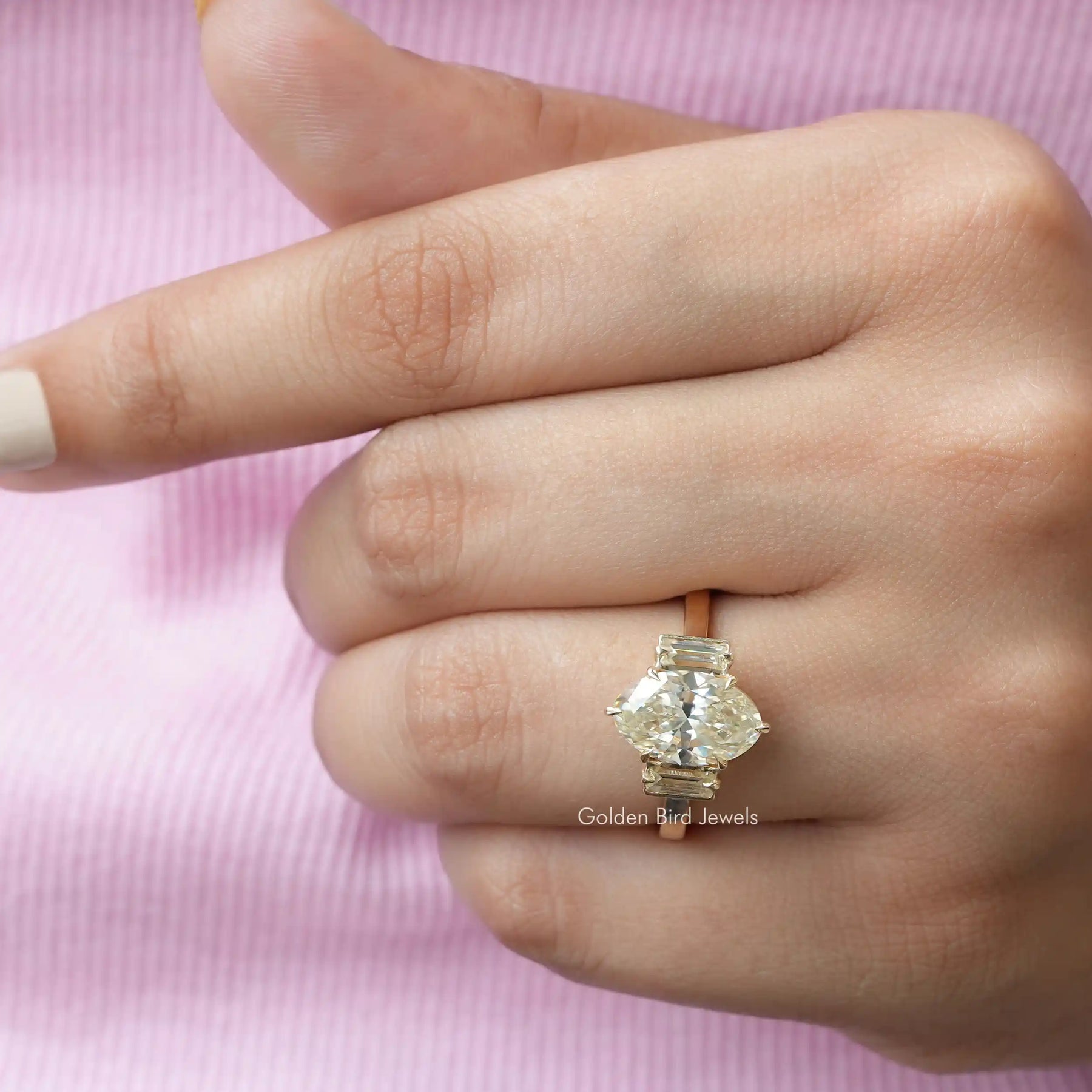 Top view of three-stone moissanite ring in yellow gold