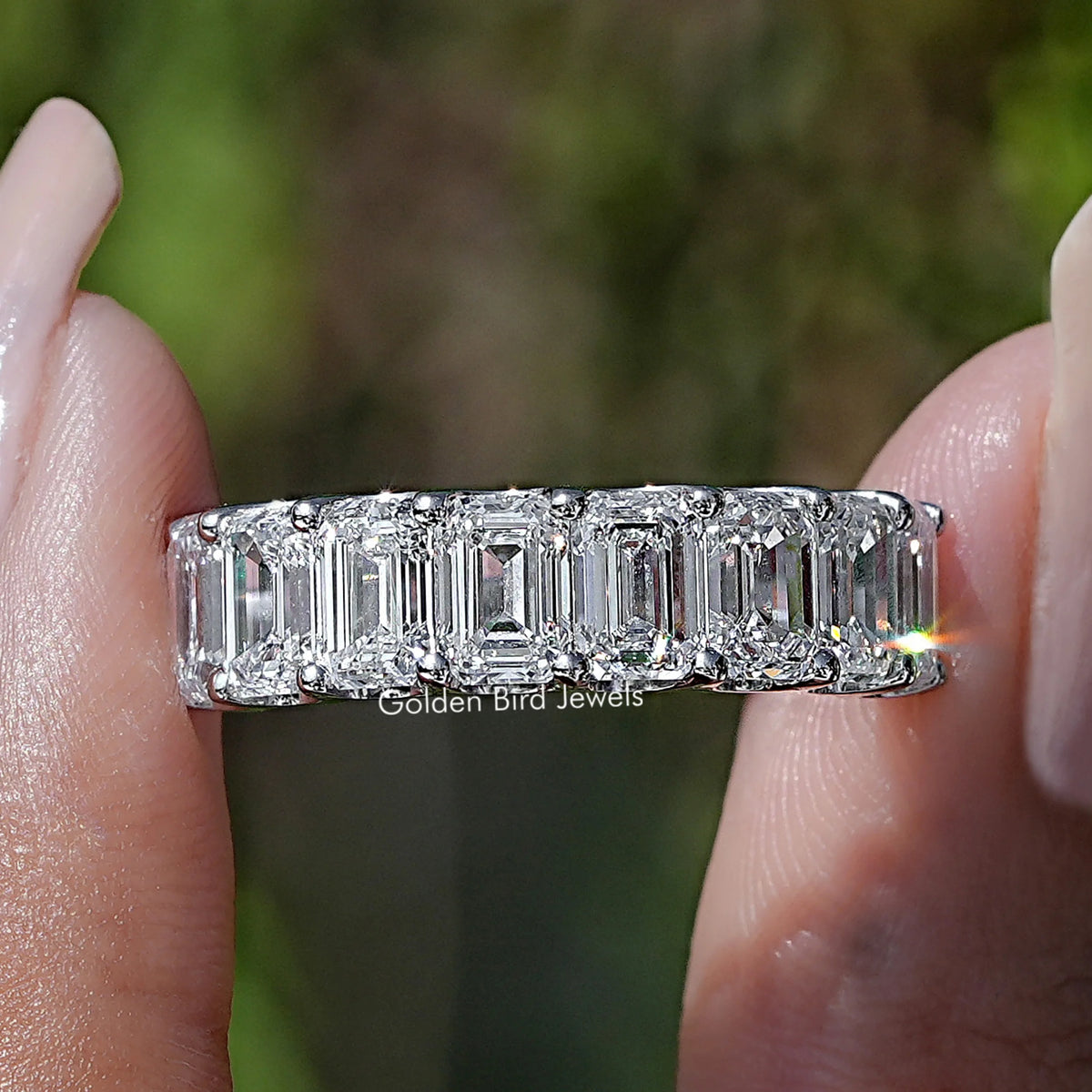 Emerald Cut Lab Diamond Half Eternity Band Held Between Fingers