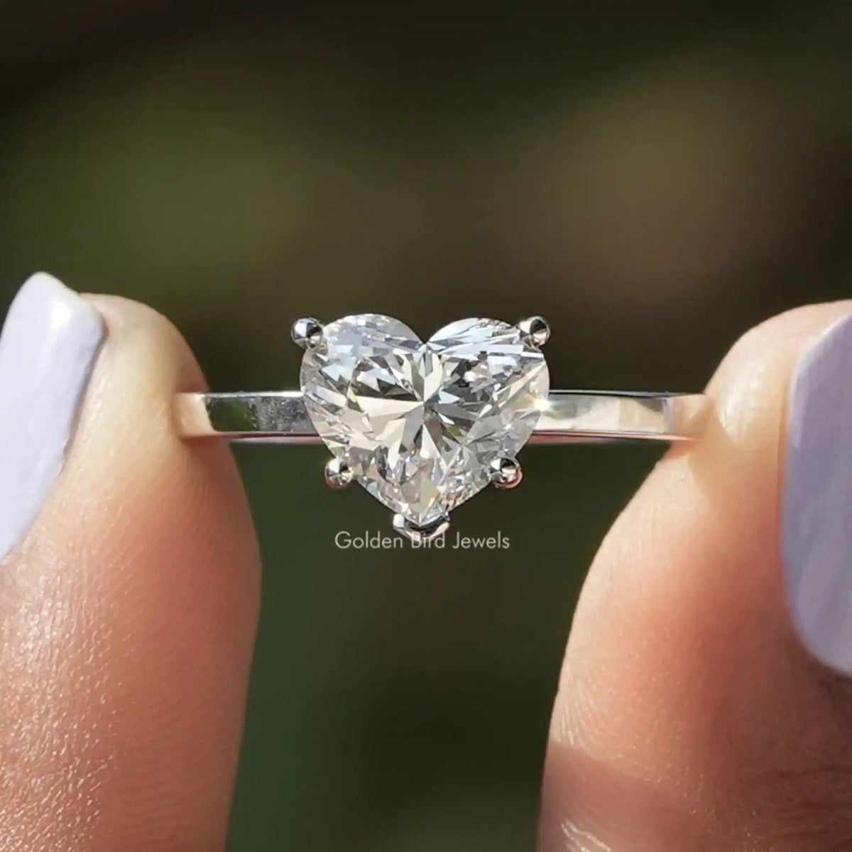 Brilliant Heart Shape Lab Diamond Solitaire Ring Held Between Fingers