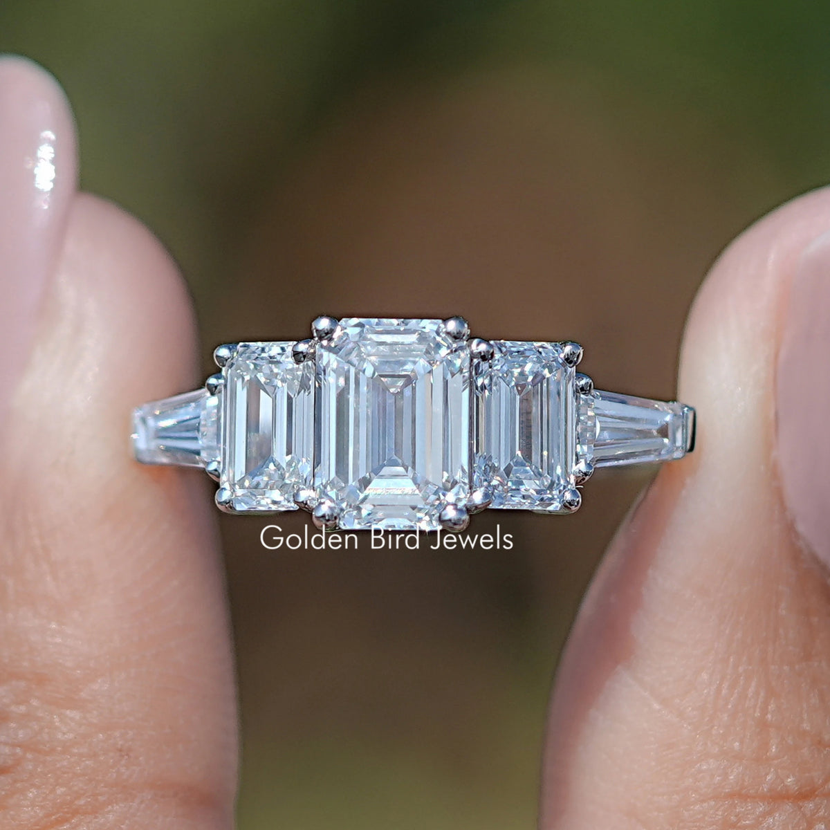 Lab Diamond Emerald Cut Five Stone Ring Between Fingers