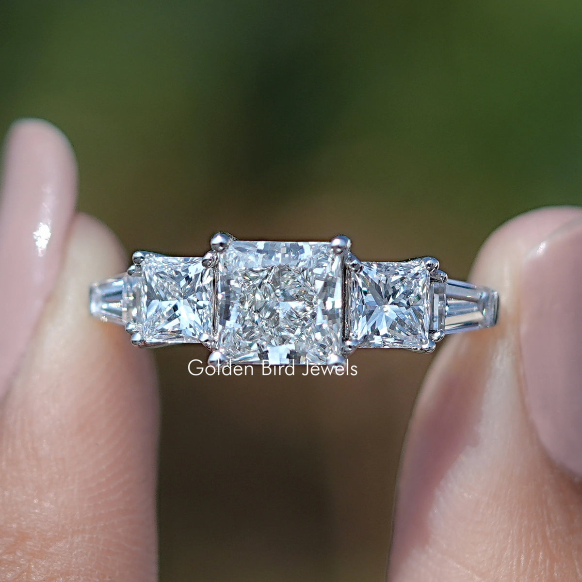 Princess Cut Lab Grown Diamond Five Stone Ring Held Between Fingers