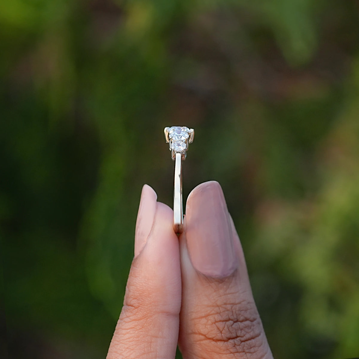 Side View of Round Cut Diamond Five Stone Ring In two fingers