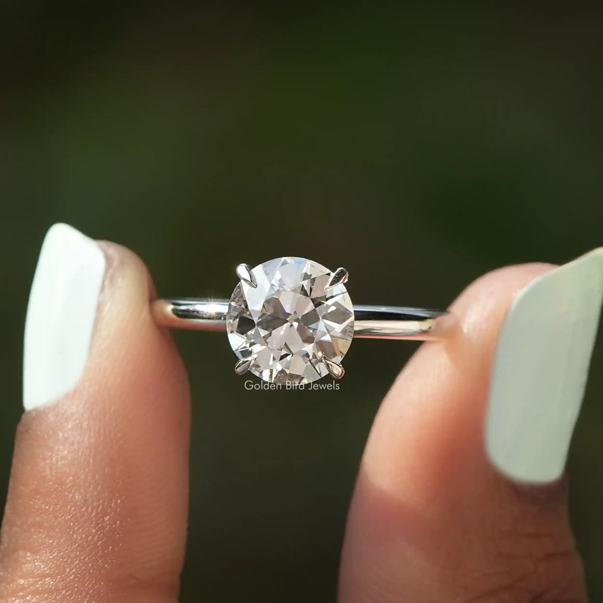 Two fingers holding the Old European Round Diamond Ring