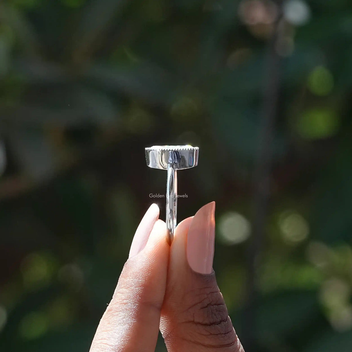 Side View of Old Mine Oval Engagement Ring In two fingers