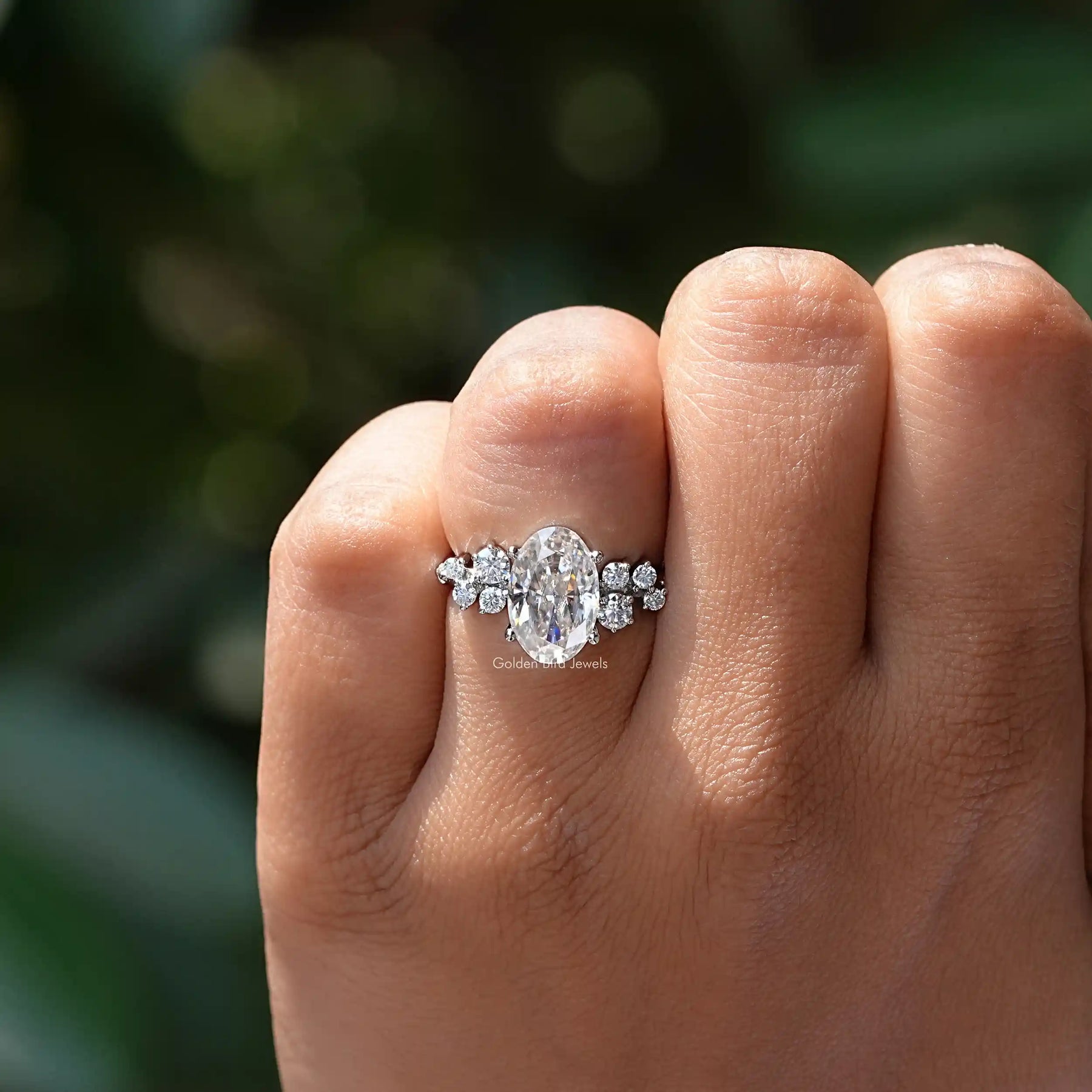In finger front view of oval cut engagement ring in white gold