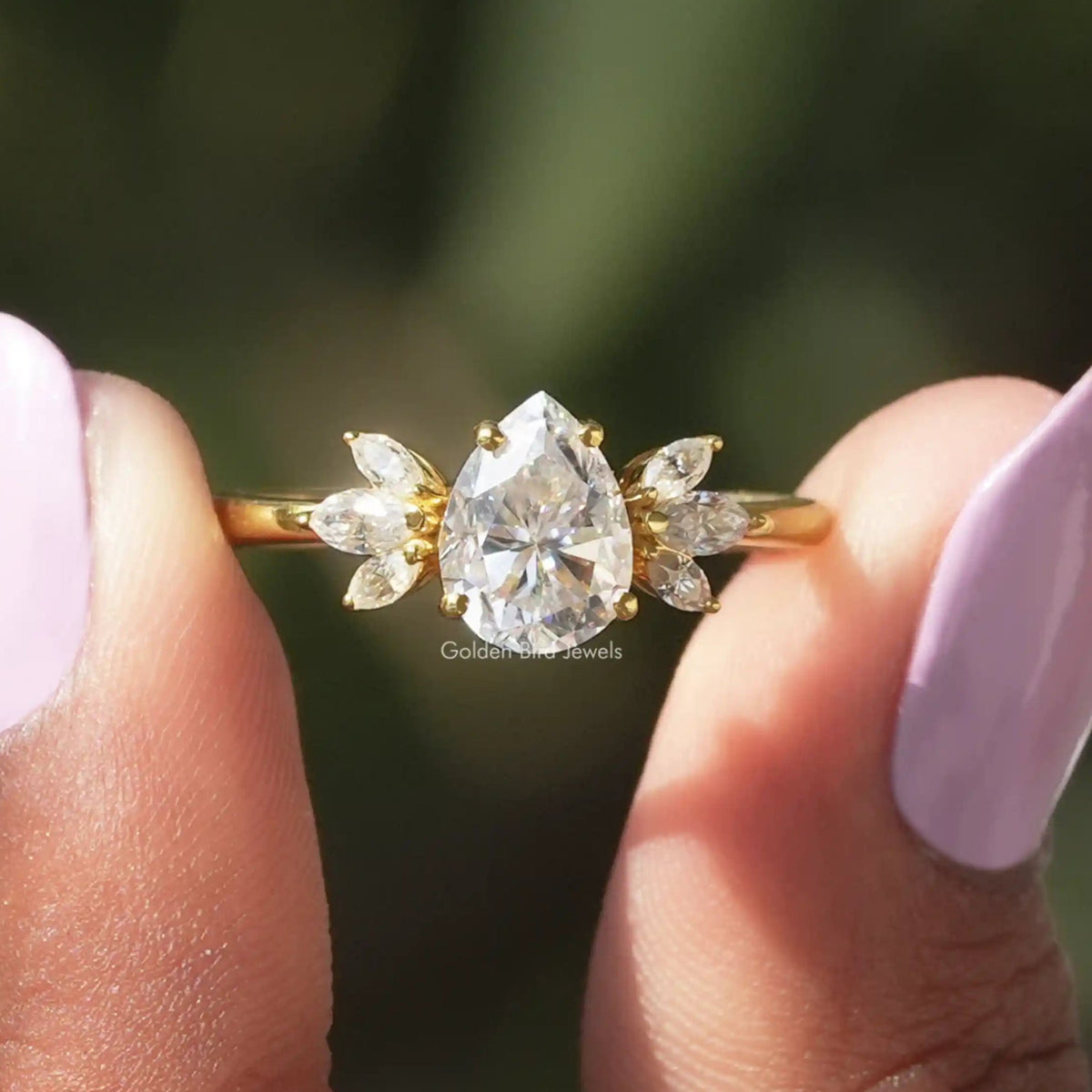 Two fingers holding the Pear Cut Marquise Engagement Ring