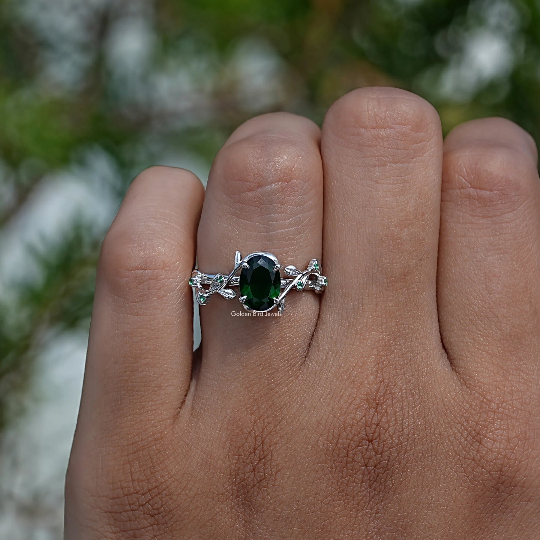 Close-Up View of Green Oval Cut Gemstone Engagement Ring In White Gold