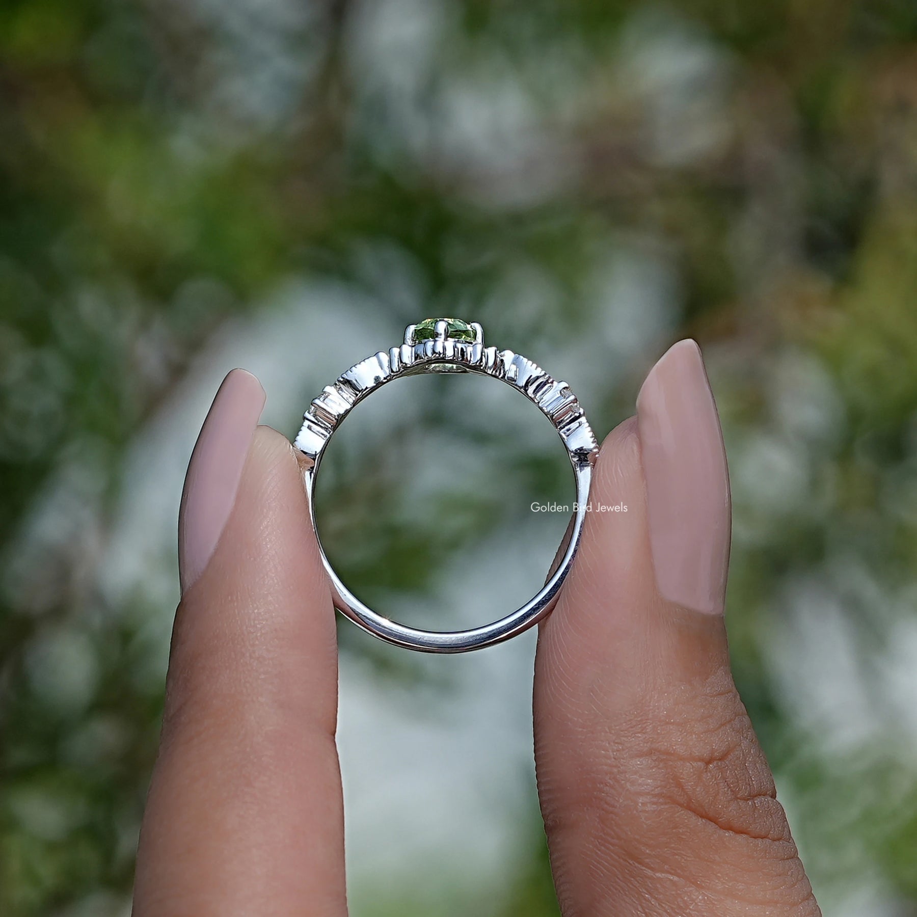 Back View of Peridot Green Oval Cut Engagement Ring In two fingers
