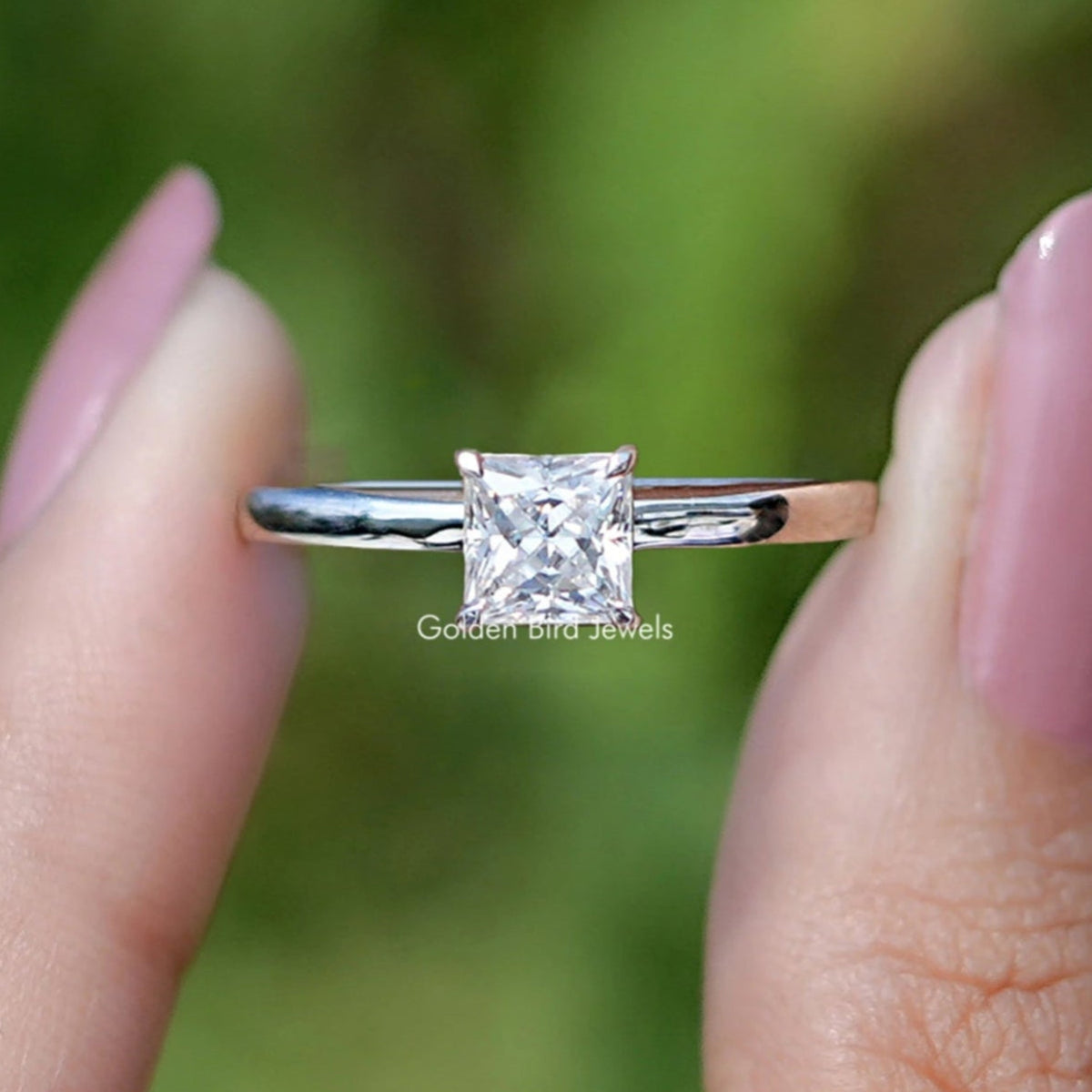 Front view of Princess Cut moissanite engagement ring holding in two fingers