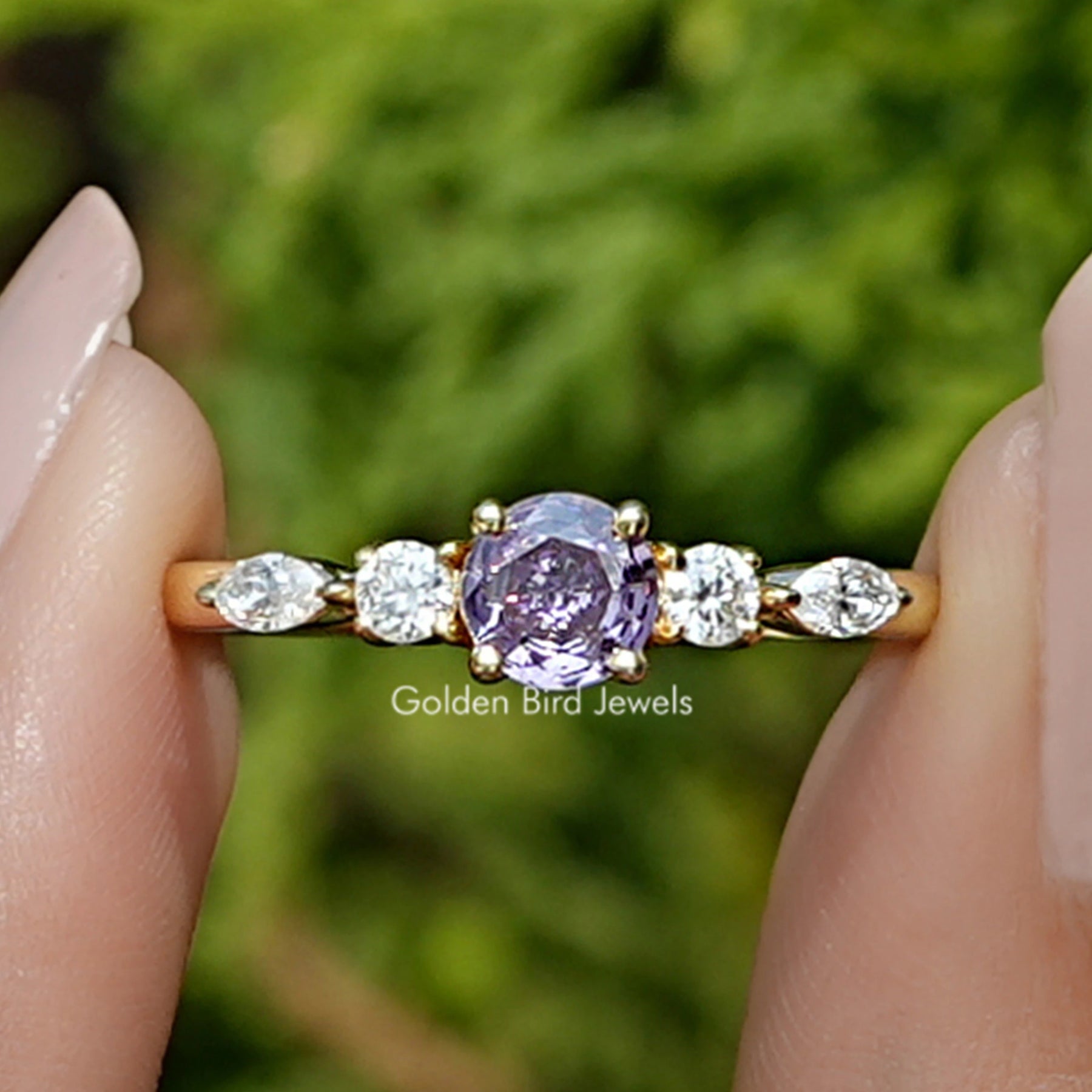 Front view of Amethyst Round Cut Gemstone Accent Ring in two fingers