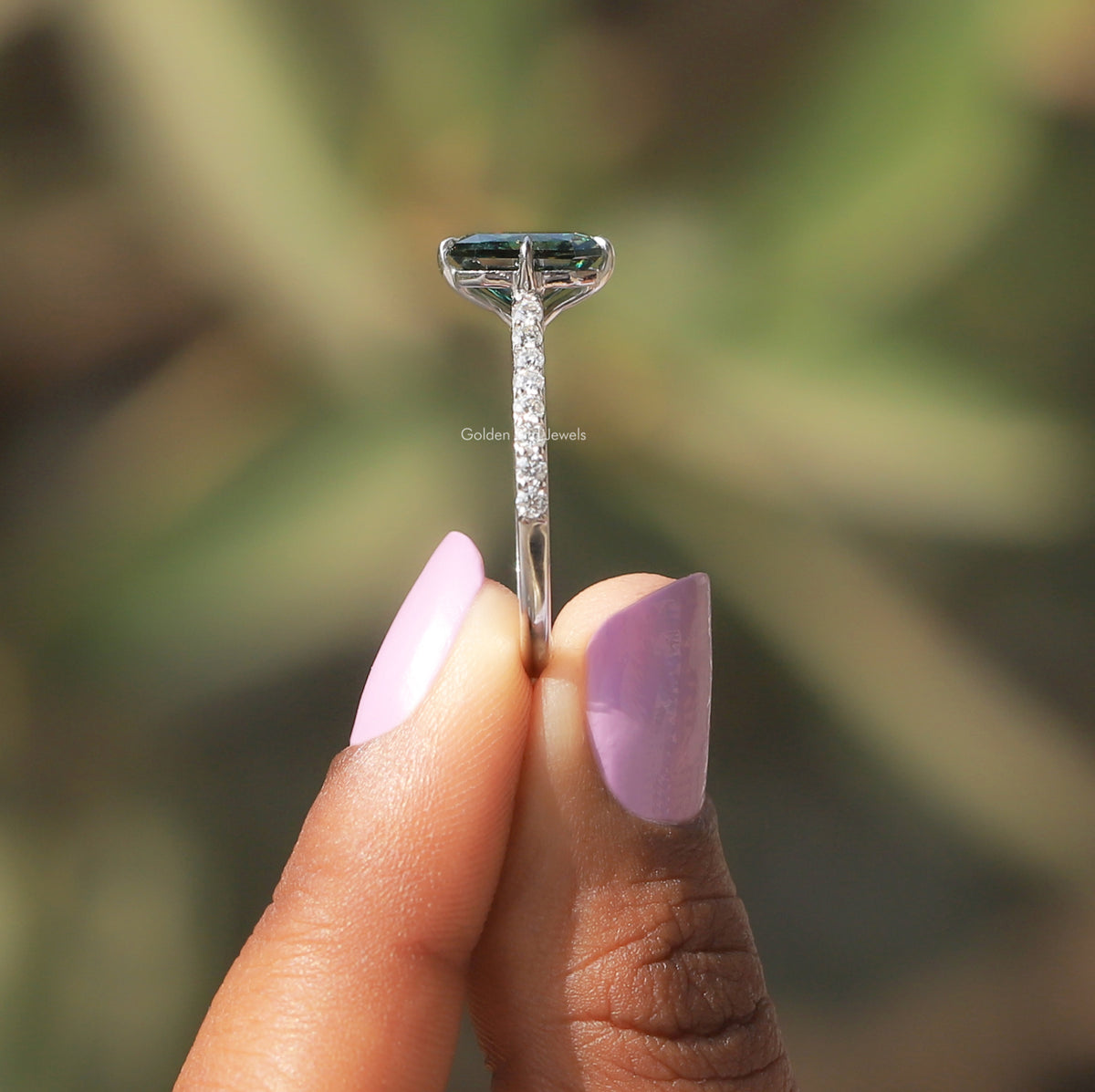 Side View of Green Radiant Cut Moissanite Ring In two fingers