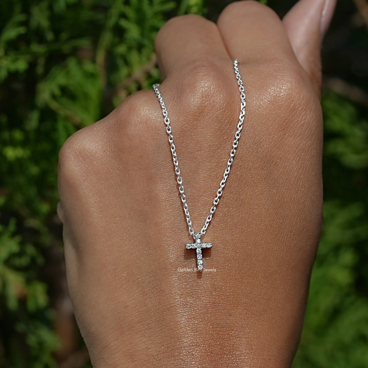 In hand holding View of the Round Cut Diamond Cross Pendant In White Gold