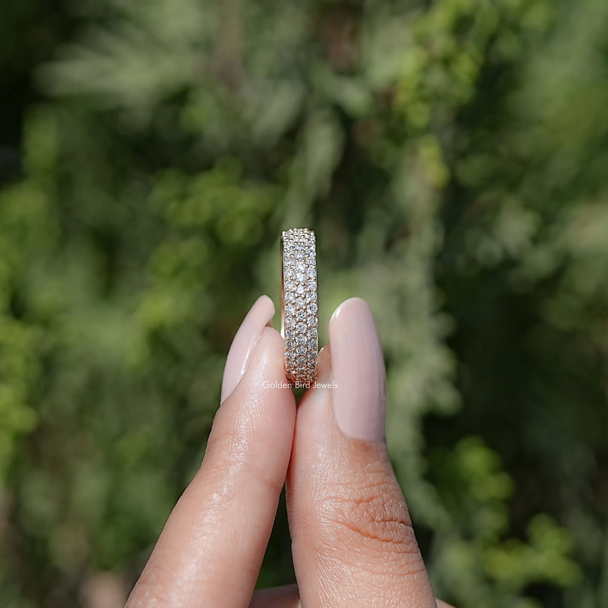 Side View of Round Cut Diamond Three Row Band Held in Two Finger