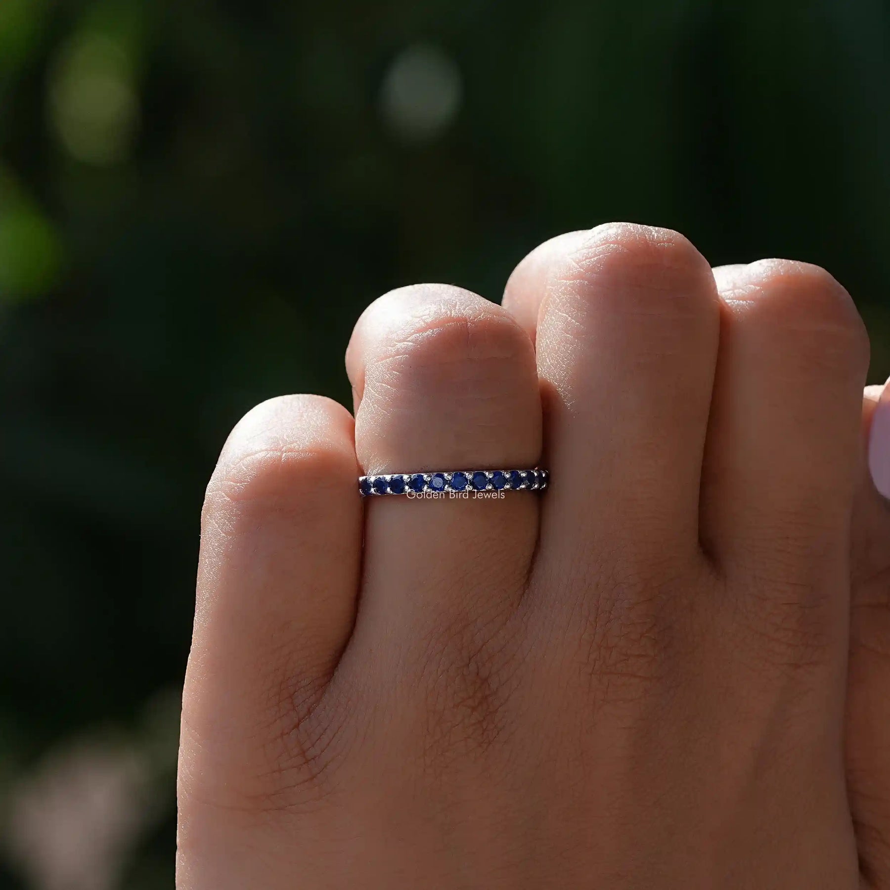 View of Sapphire Blue Round Eternity Band in prongs setting
