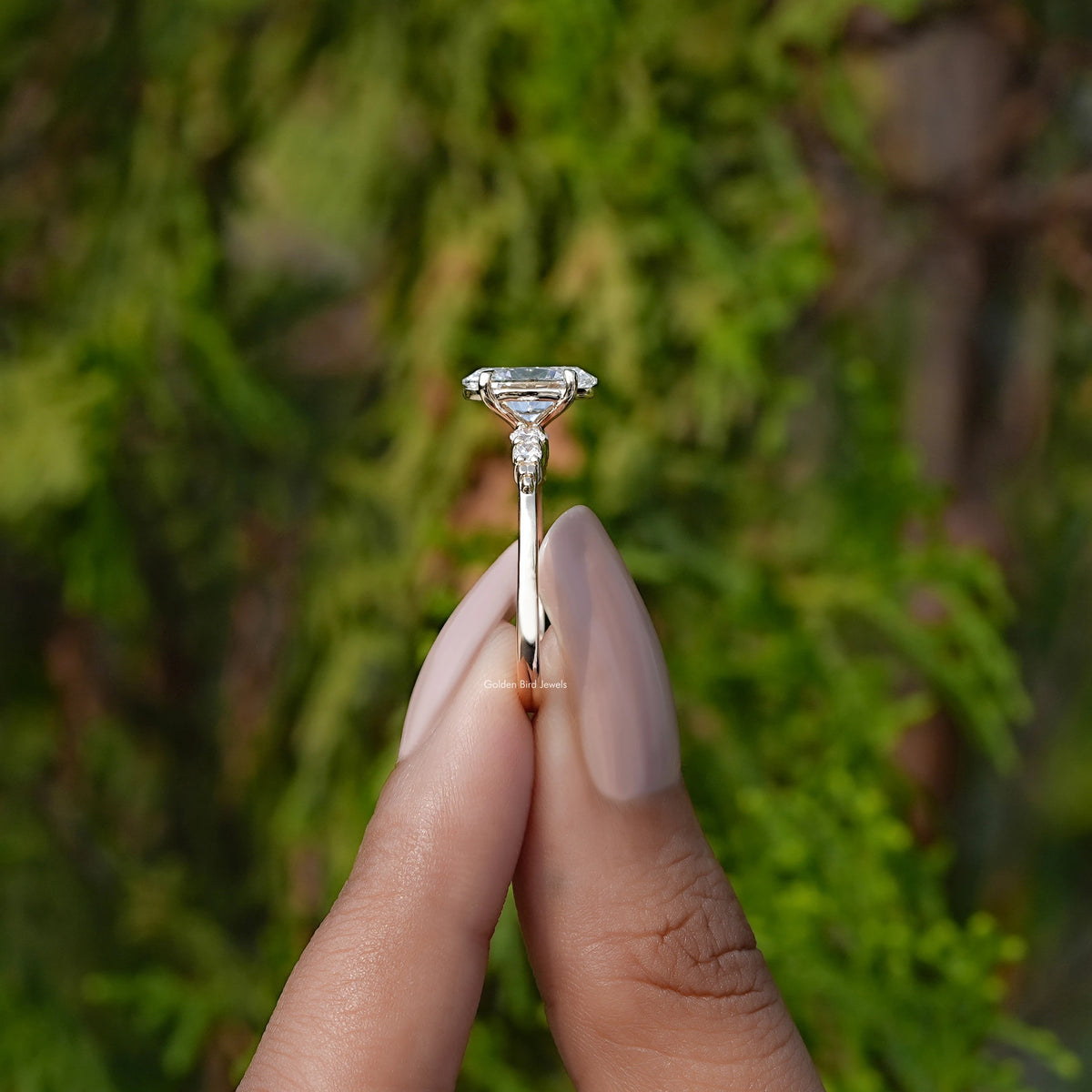 Side View of Oval And Round Cut Lab Diamond Accent Set Ring In two fingers