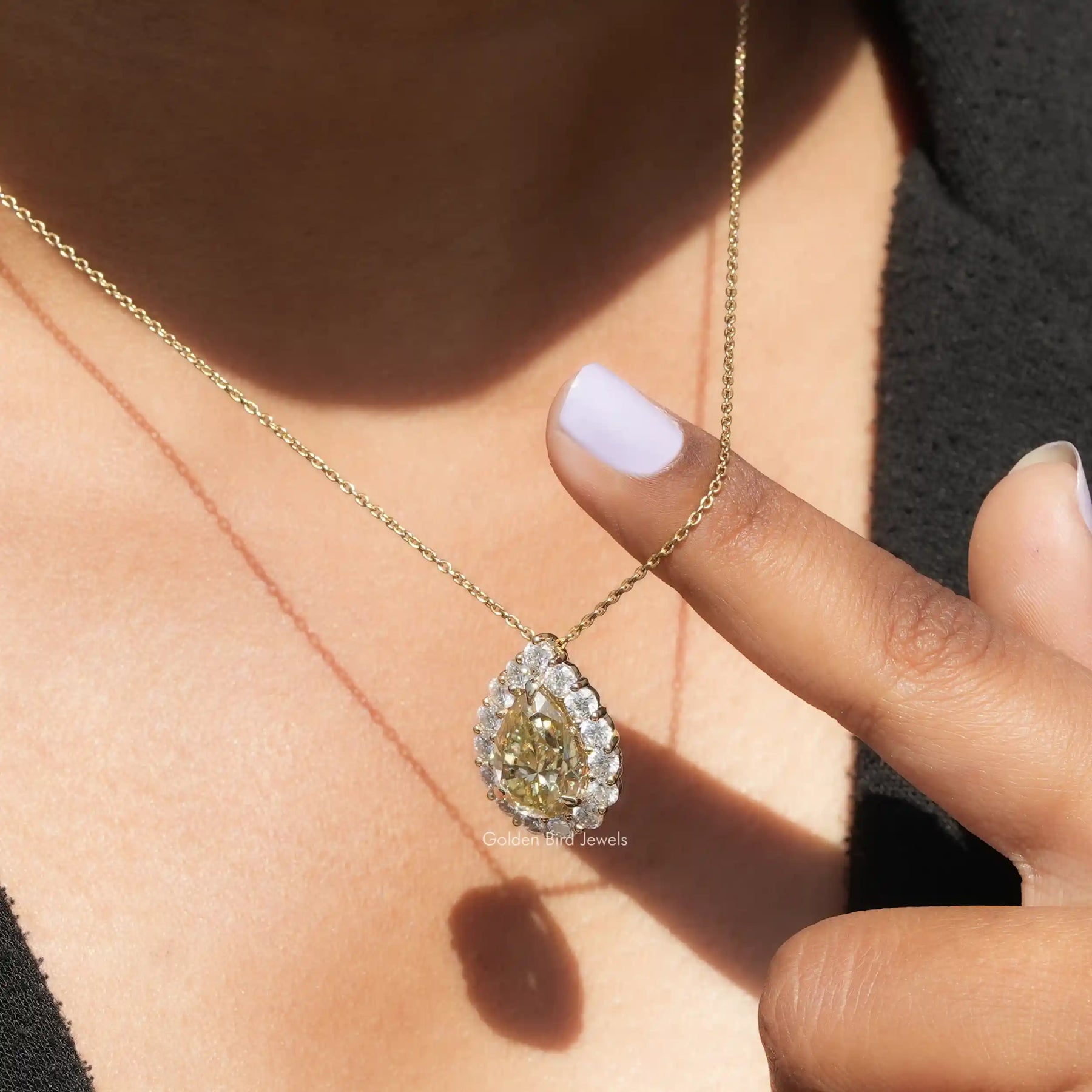 Side view of pear Cut pendant In white Gold