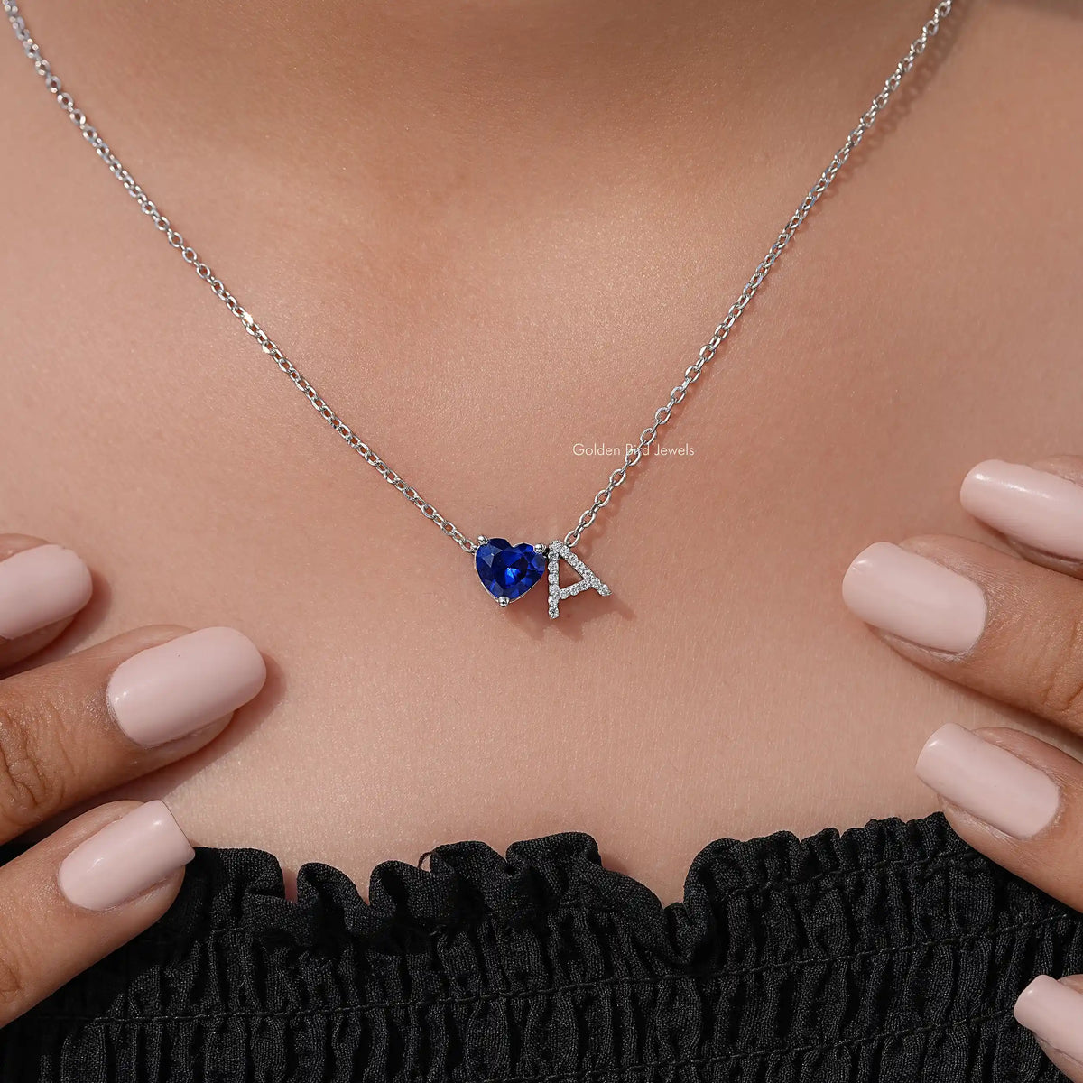 Blue heart gemstone initial pendant necklace with silver chain and A charm on hands