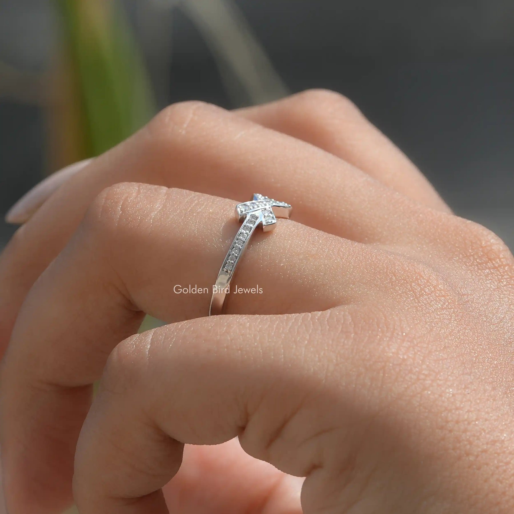 [in finger side view of ribbon style round cut moissanite ring set in bezel setting]-[Golden Bird Jewels]
