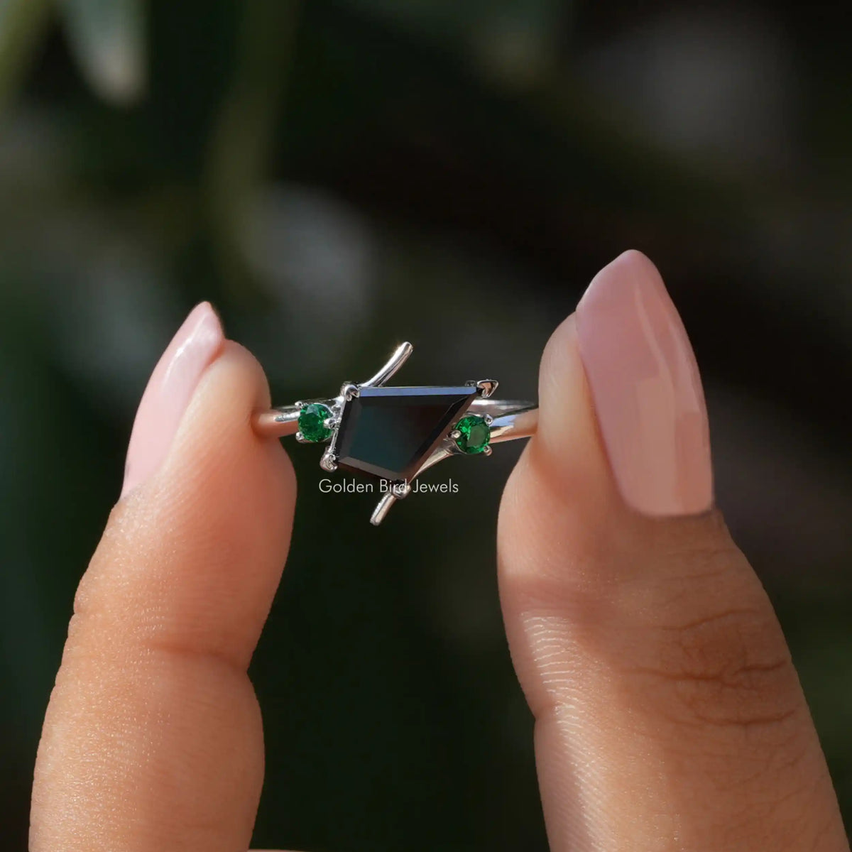 Two fingers holding the Black Kite Cut Moissanite Engagement Ring
