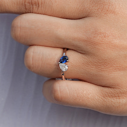 Sterling silver toi et moi ring on finger with blue pear and white pear stones