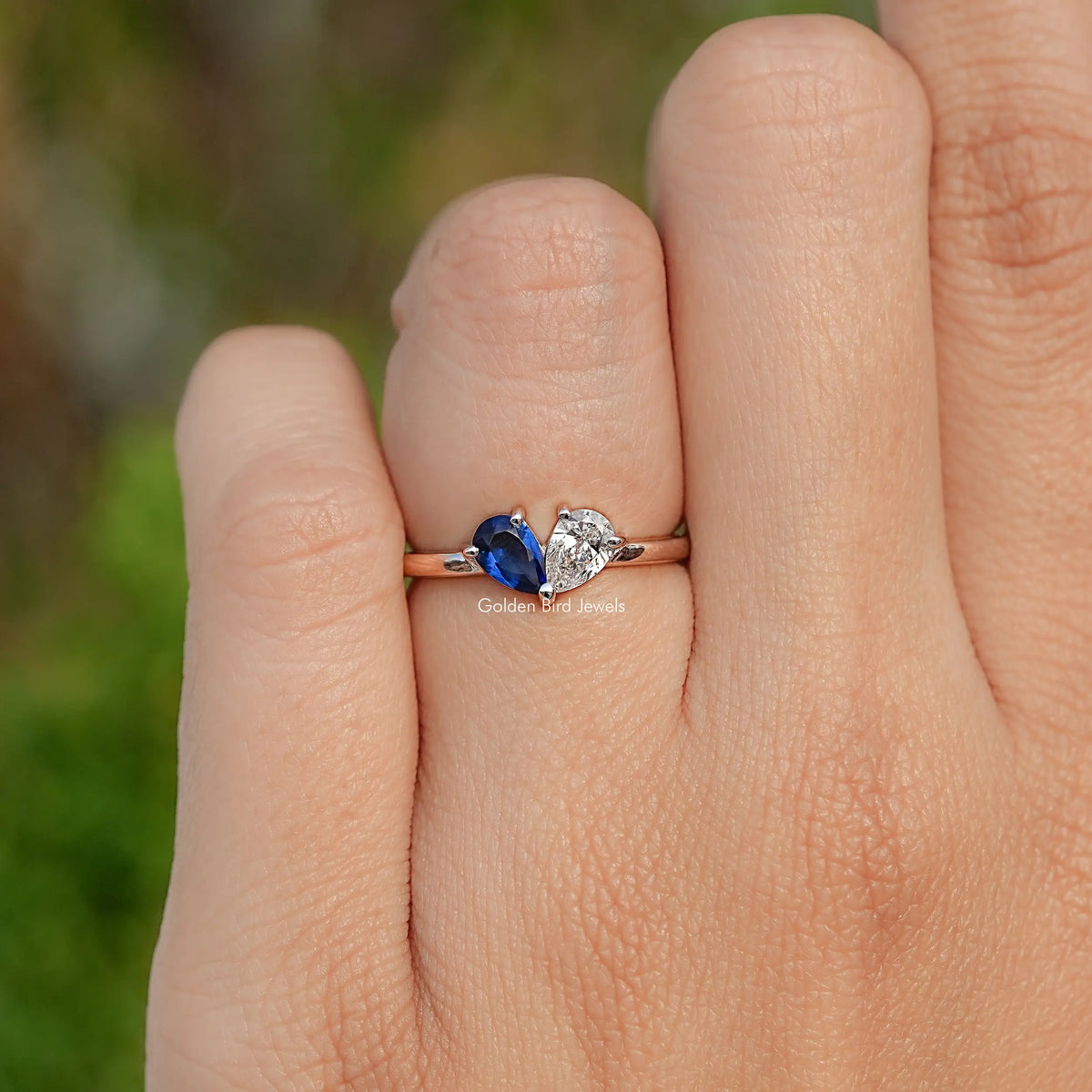 Sterling silver engagement ring with blue pear center stone and white pear side stone