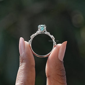 Back View of Marquise Cut Moissanite Ring With Round Cut Side Stones In two fingers