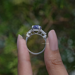 Back View of Emerald Cut Gemstone Engagement Ring In two fingers