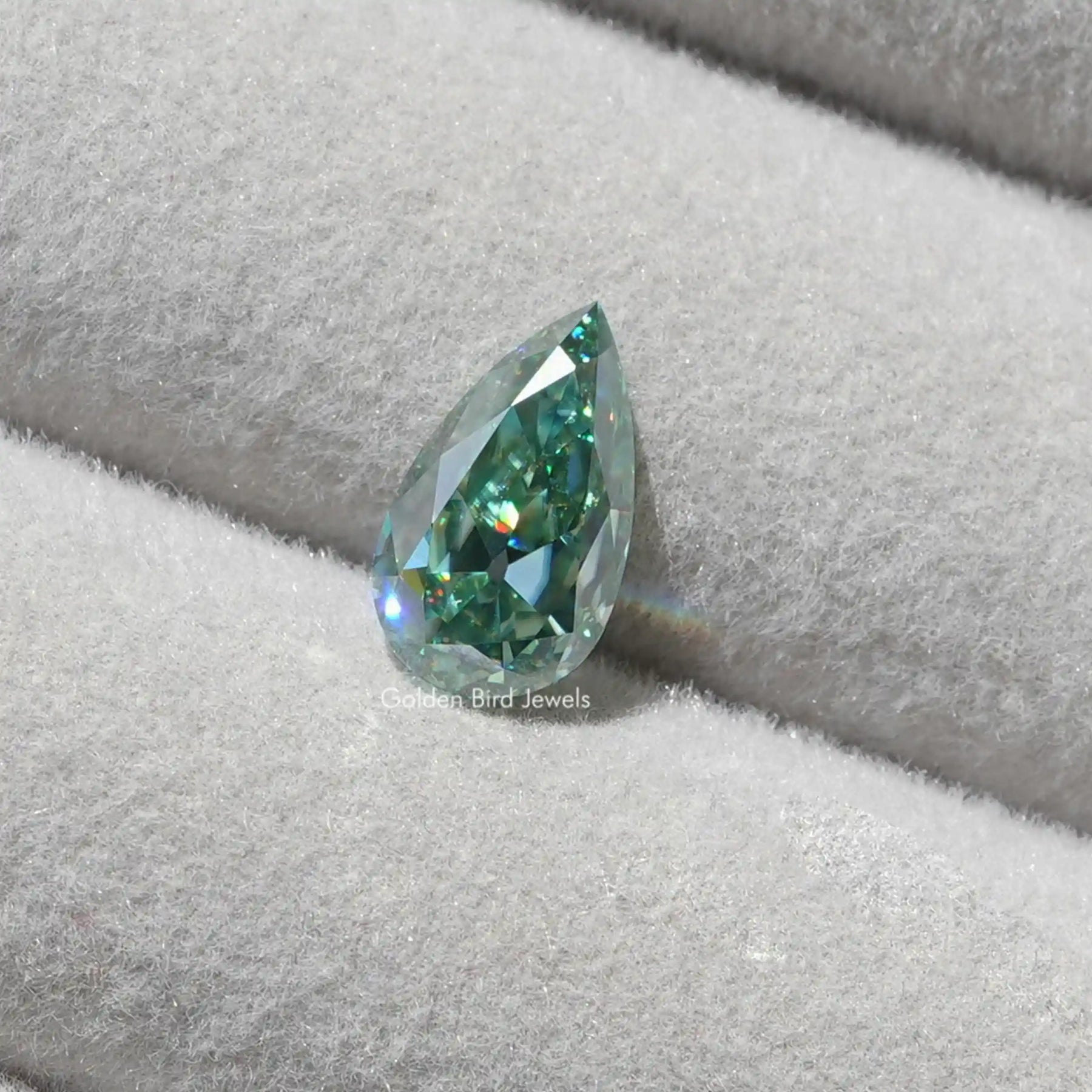 [This pear cut loose moissanite crafted with blue green color and ]