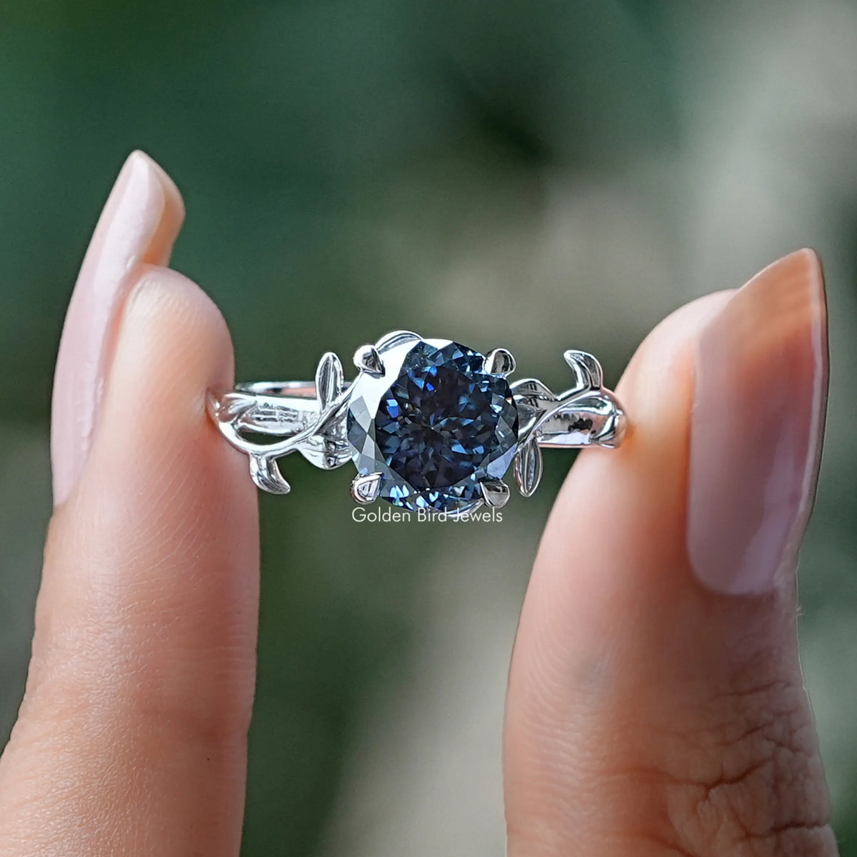 Two fingers holding the Portuguese Cut Round Moissanite Engagement Ring