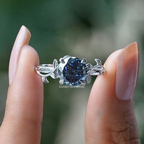 Two fingers holding the Portuguese Cut Round Moissanite Engagement Ring