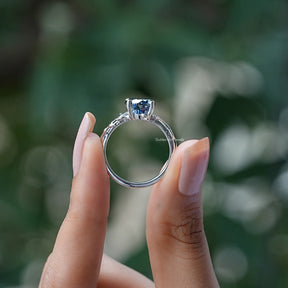 Back View of Blue Portuguese Cut Round Moissanite Ring In two fingers